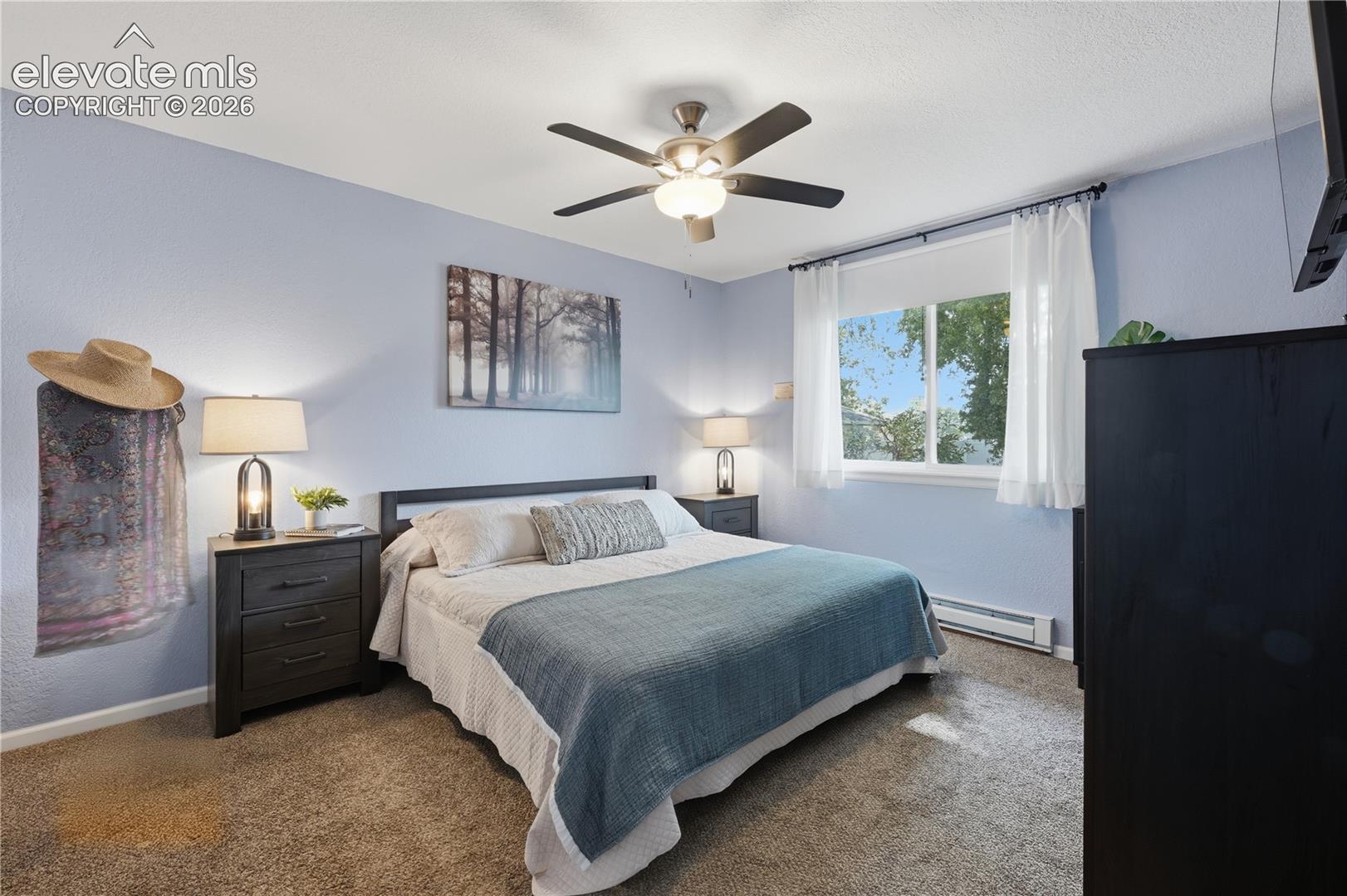 Spacious primary bedroom with neutral finishes, plush carpeting, and plenty of room to unwind at the end of the day.