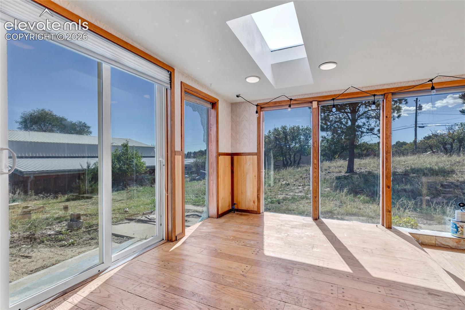 Wood-finish flooring with multiple skylights and recessed lighting