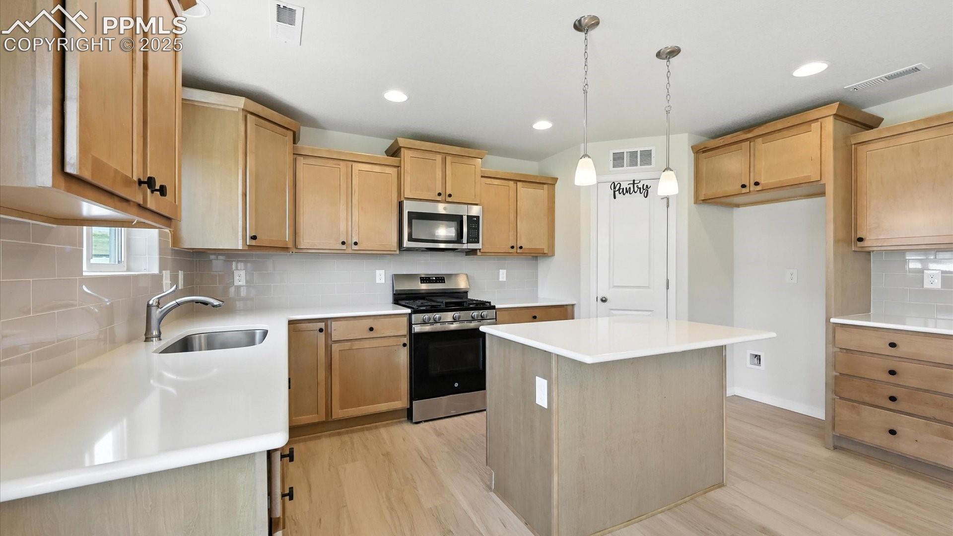 The Kitchen is a delight with quartz countertops, subway tile backsplash, pantry, & stainless appliances including a gas range oven, built-in microwave, & dishwasher. 