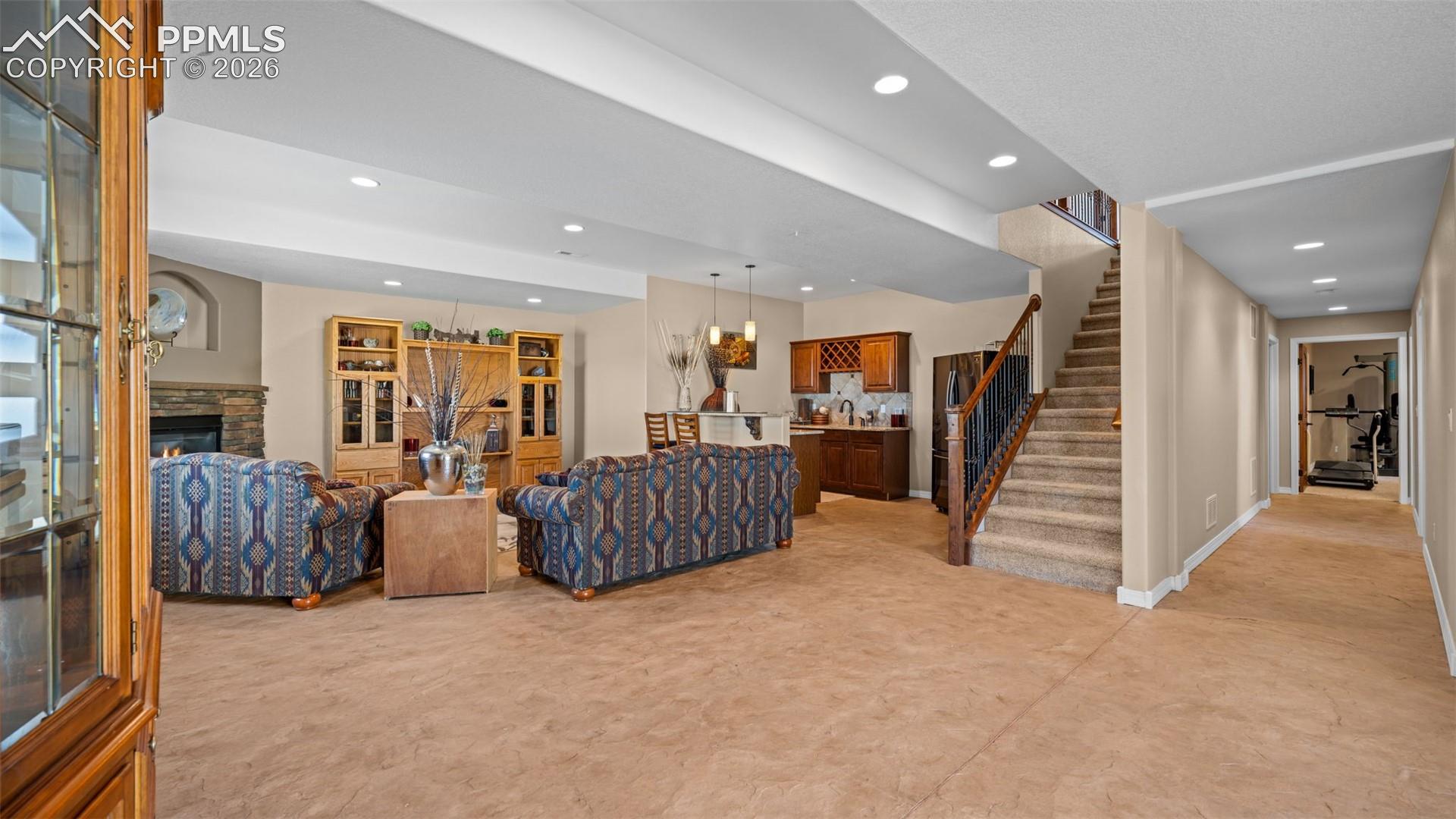 Living area with a fireplace, recessed lighting, terrific wet bar, polished, stamped concrete