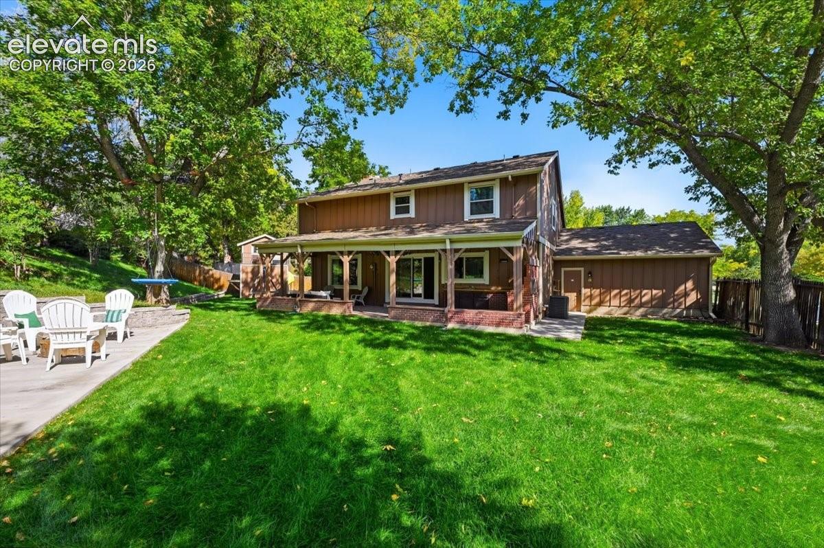 Well manicured lawn with mature trees and a covered patio, Fire pit and play space with tree house!