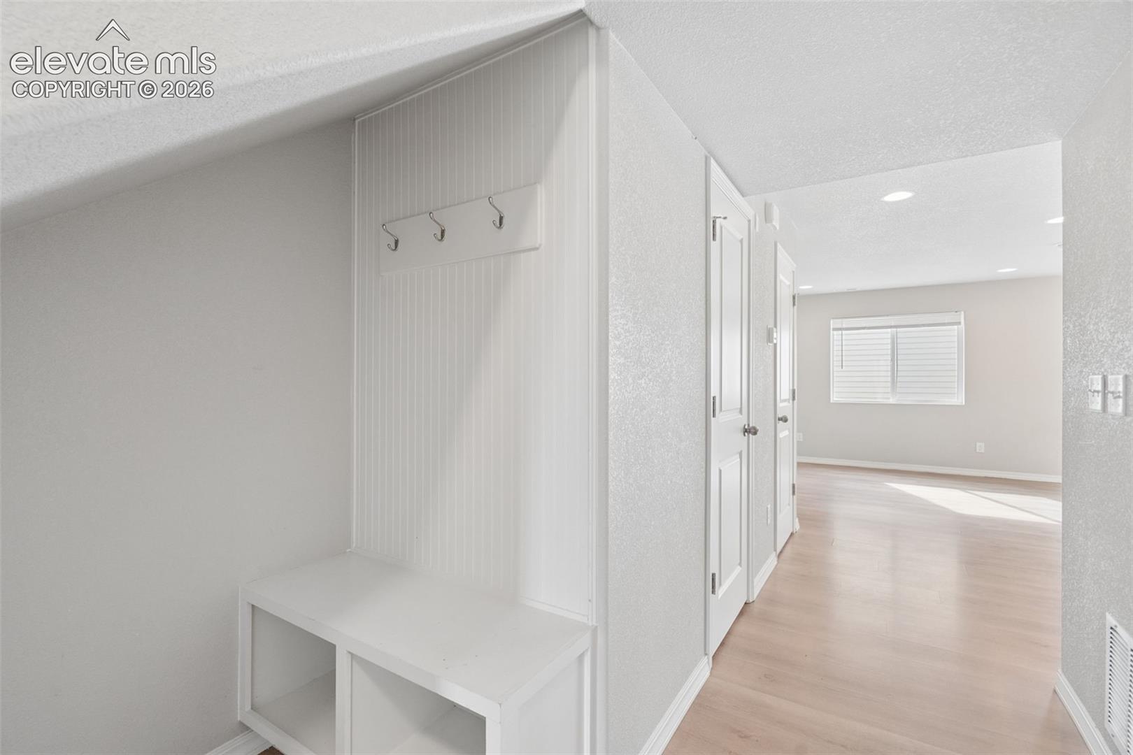Built-in shelving and hooks are conveniently located by the home's entrance for shoes, coats, and more!