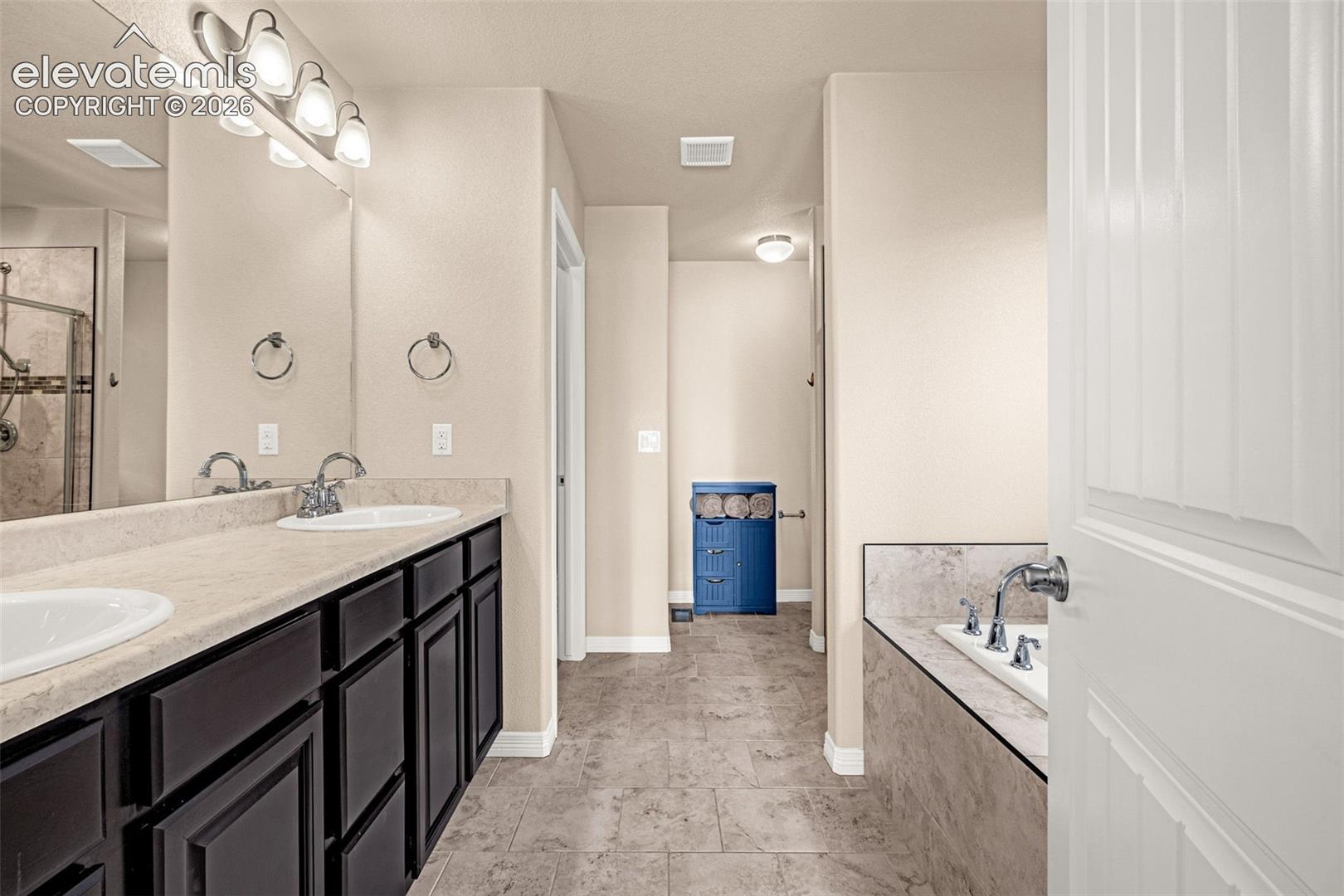 Dual vanity with integrated sinks, brushed nickel fixtures, and dark wood-finish cabinetry