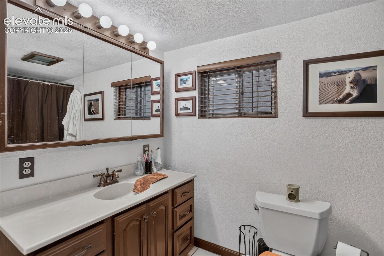 Vanity with built-in storage, integrated sink, and wall-mounted lighting