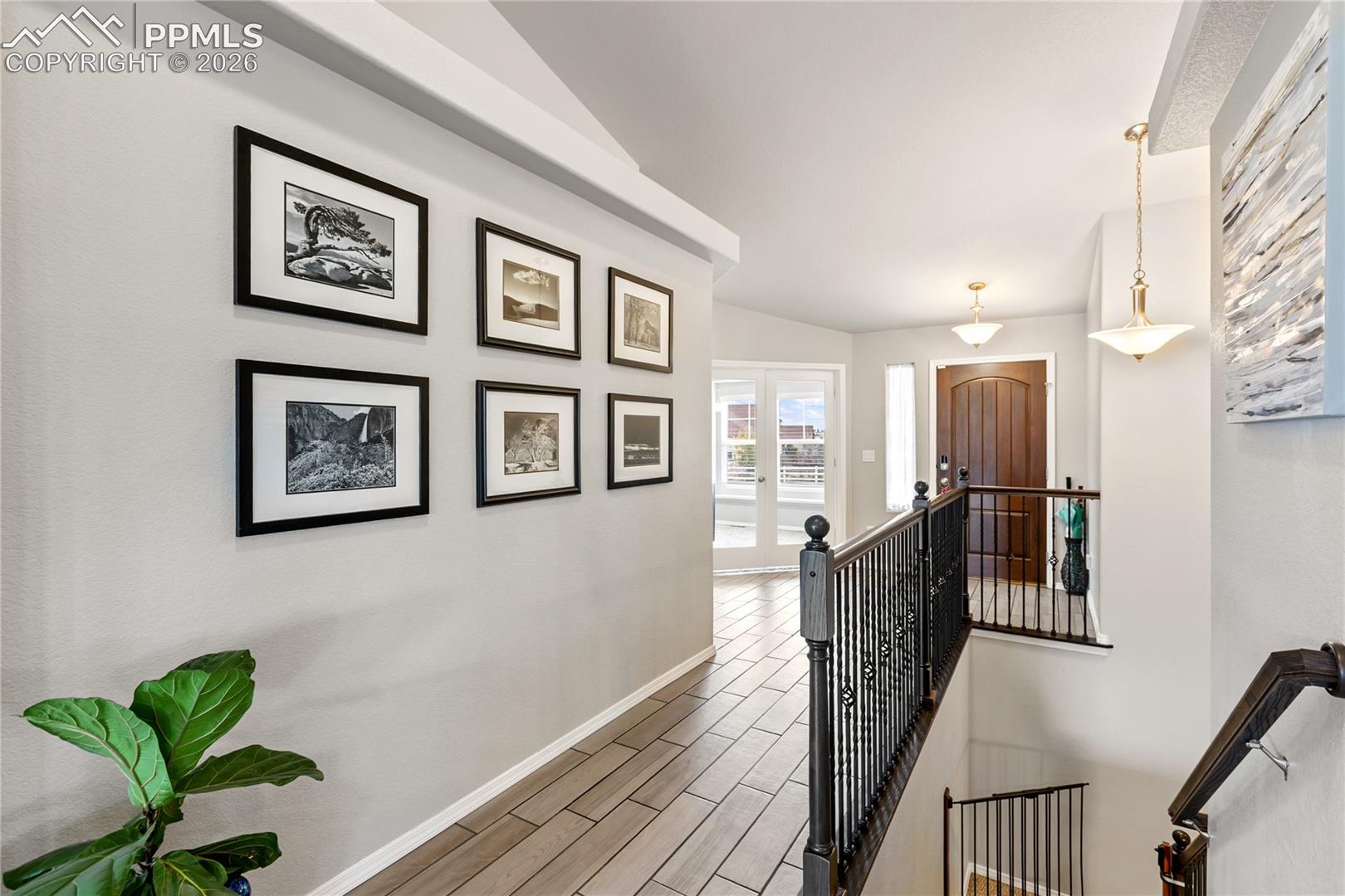 Entryway featuring ceramic tile flooring, a dark wood front door, and a banister