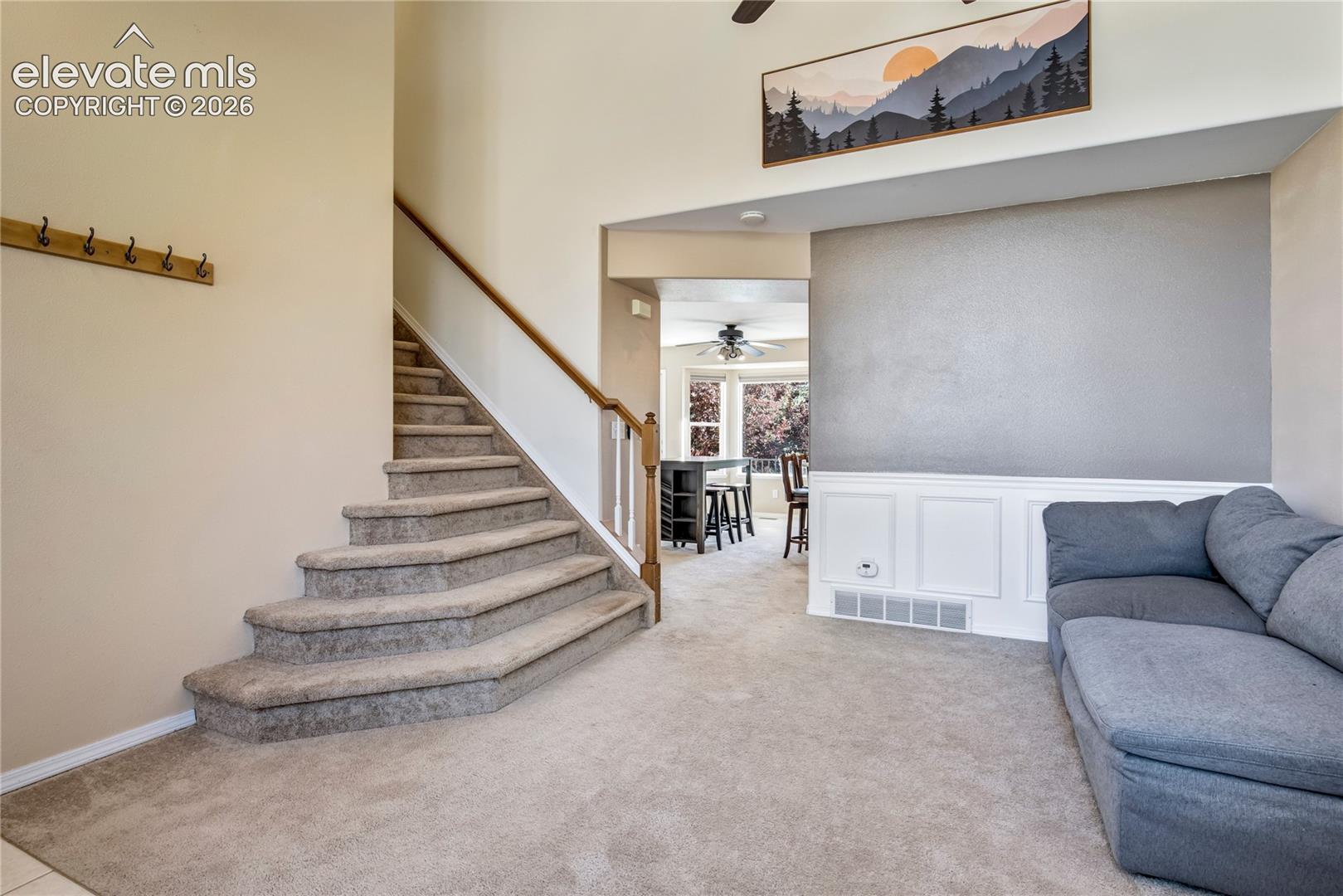 A dramatic 2-story entry opens to the light-filled living room, where vaulted ceilings, an open staircase + architectural details create a welcoming first impression.