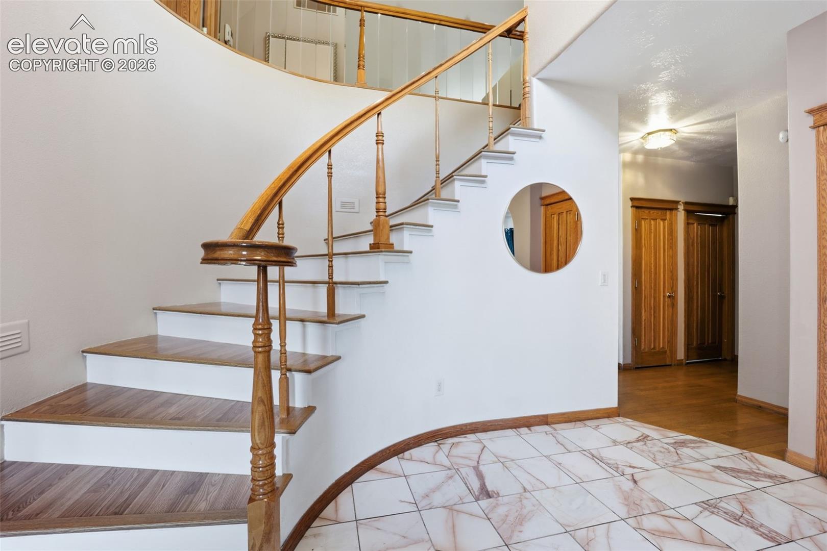 Curved staircase with wood-finish treads and balusters