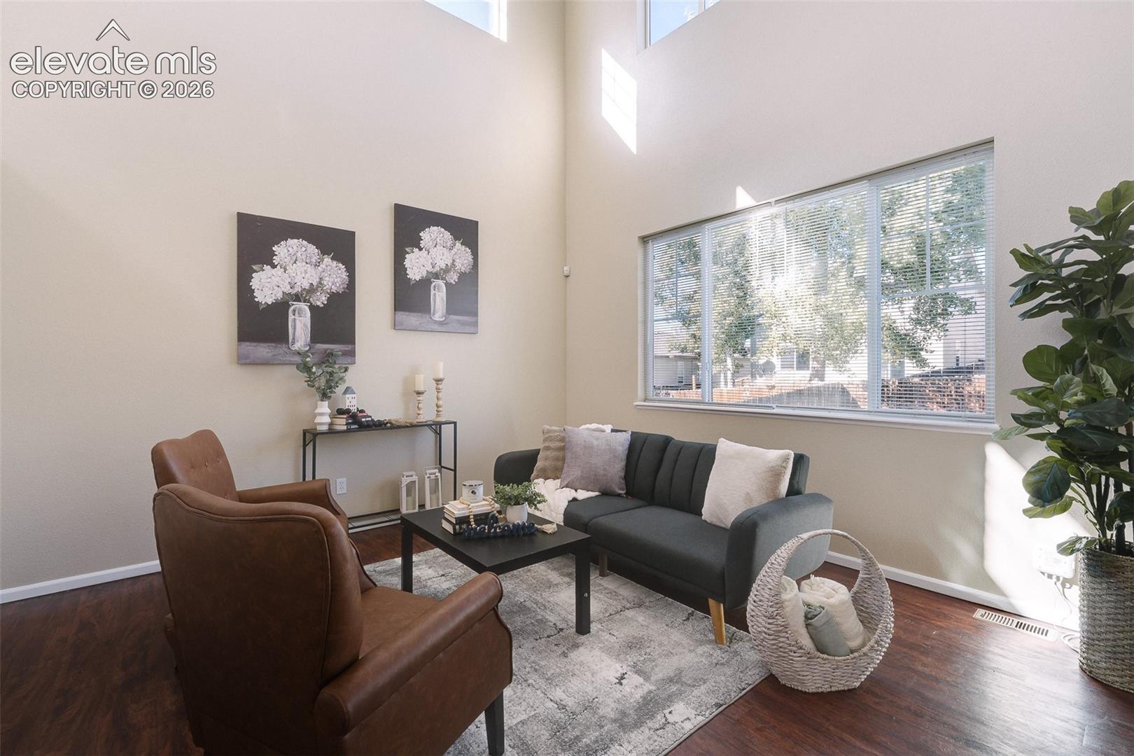 Double-height ceiling, wood-finish flooring, and expansive windows
