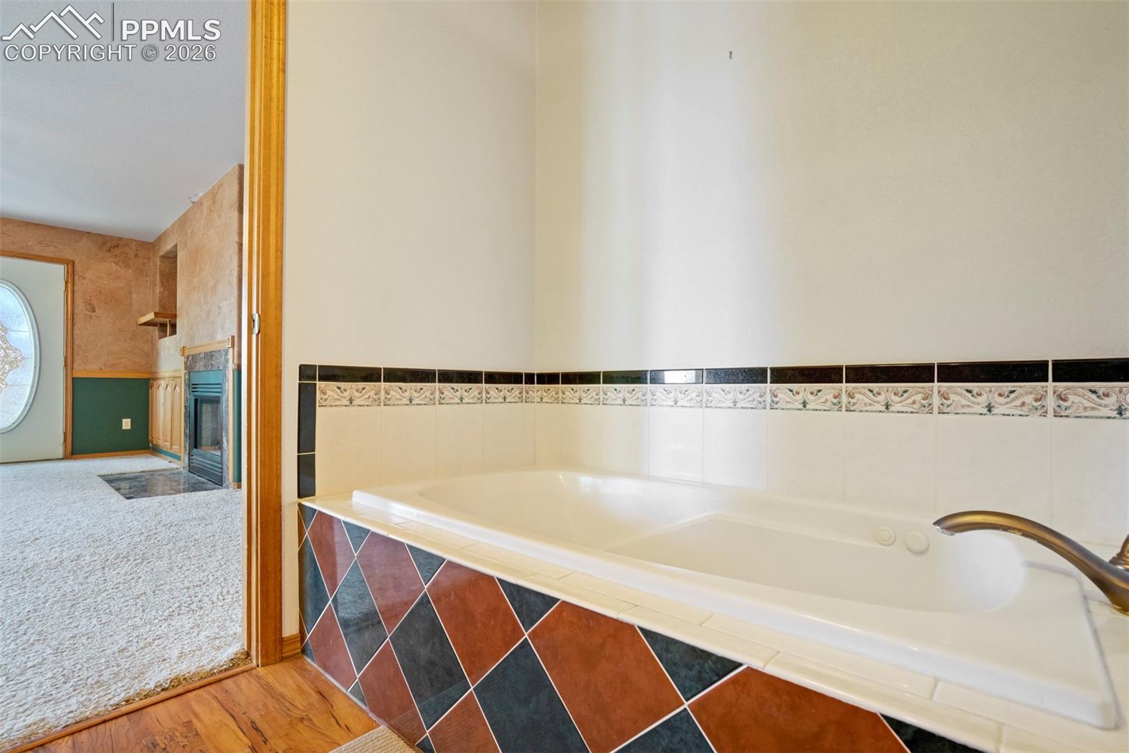 Built-in soaking tub featuring patterned tile surround