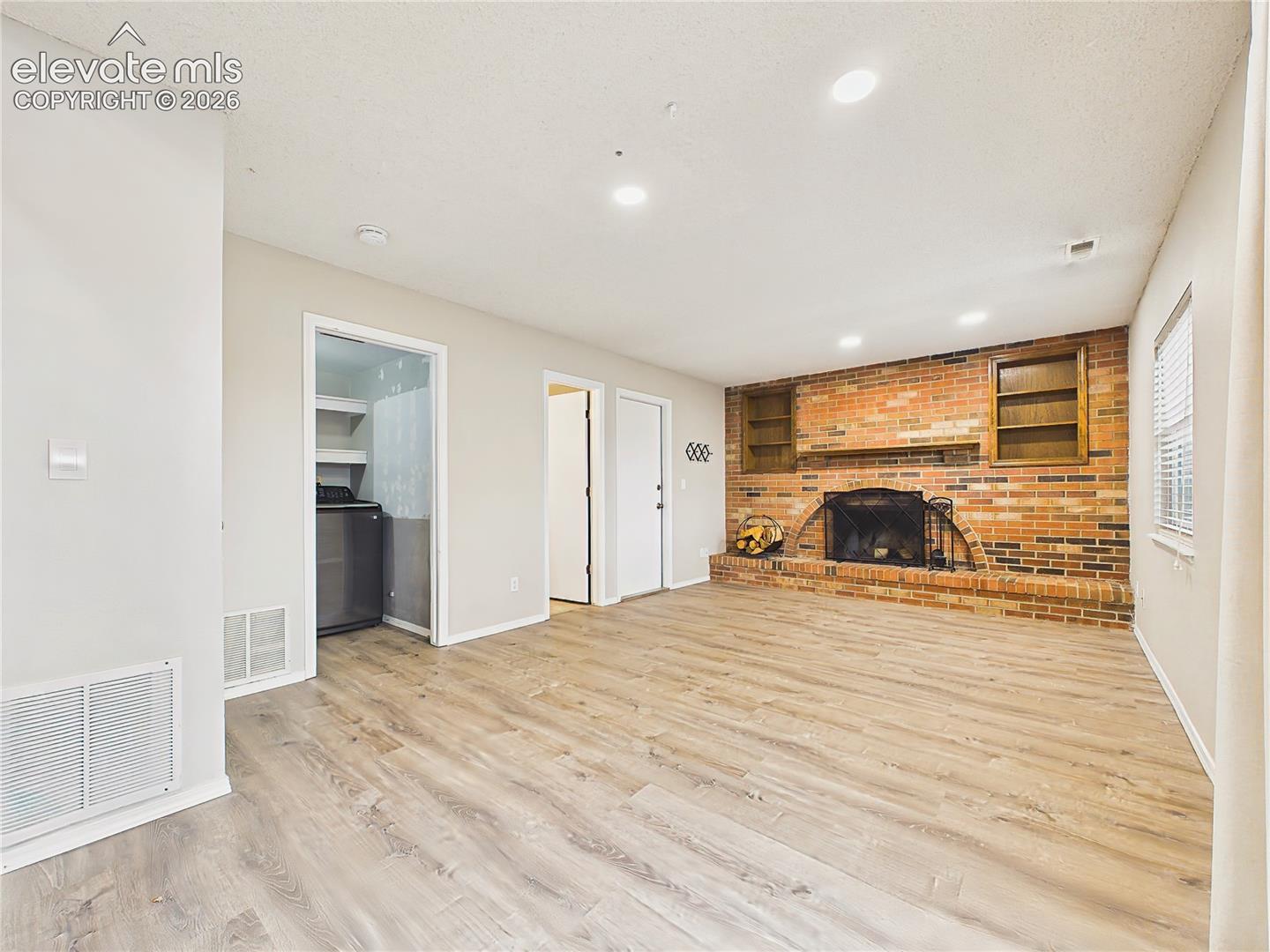 Expansive lower-level living area with recessed lighting, abundant floor space, and convenient access to the laundry room and outdoor living areas.