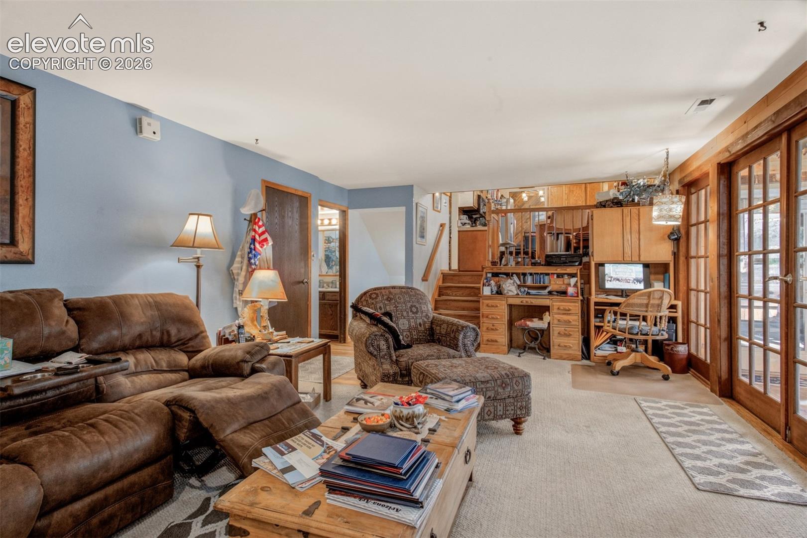 Spacious Family room featuring wood-trimmed French doors opening to the sun room. 