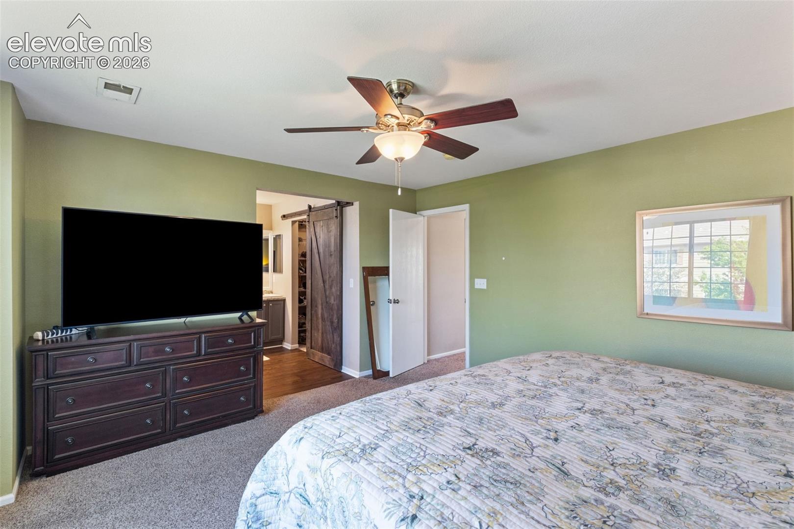 Master bedroom looking towards walk-in closet with barn door.