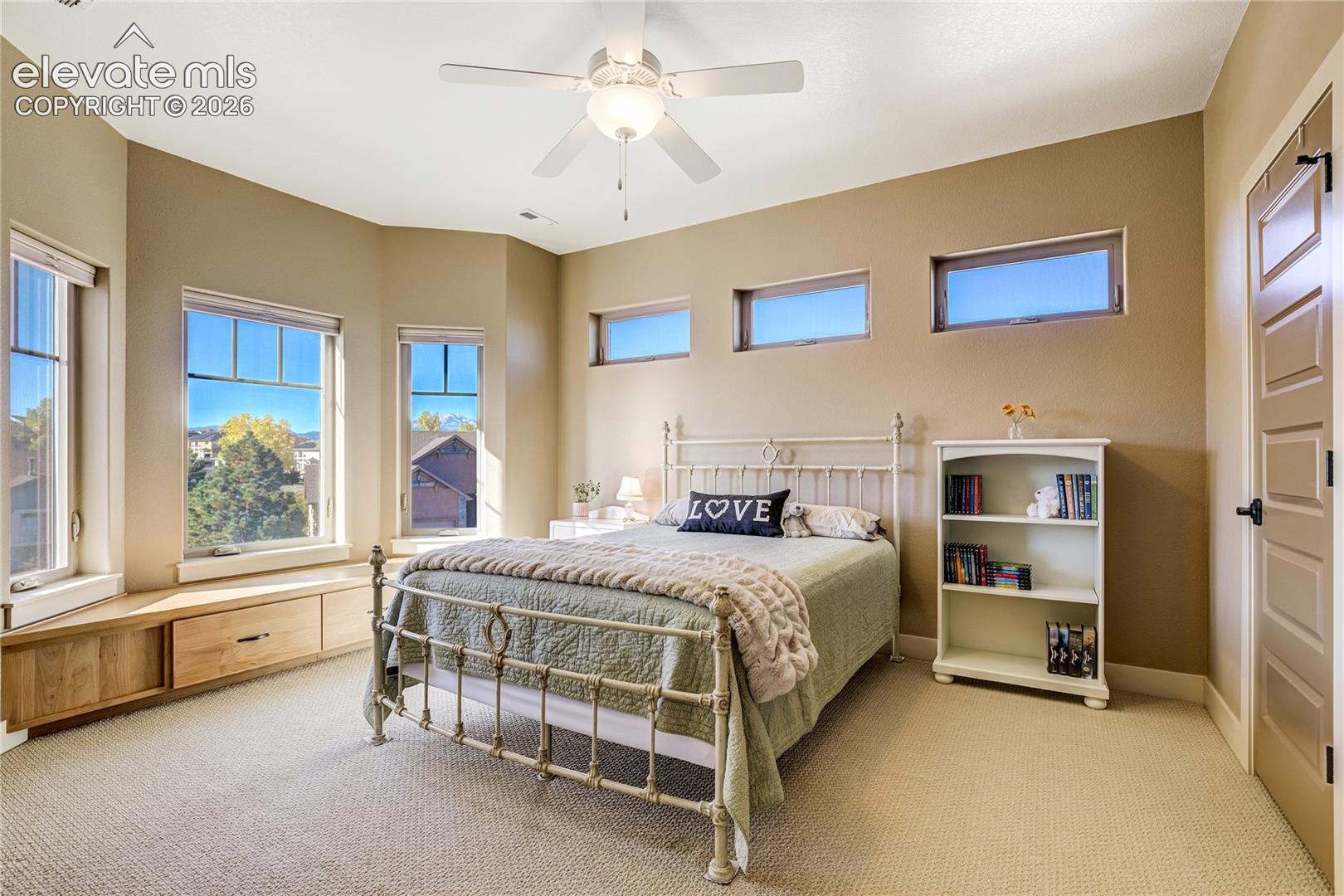 Generous windows + a built-in window seat bring warmth and character to this inviting upper-level bedroom, offering abundant natural light and a comfortable space to enjoy the surrounding Colorado scenery.