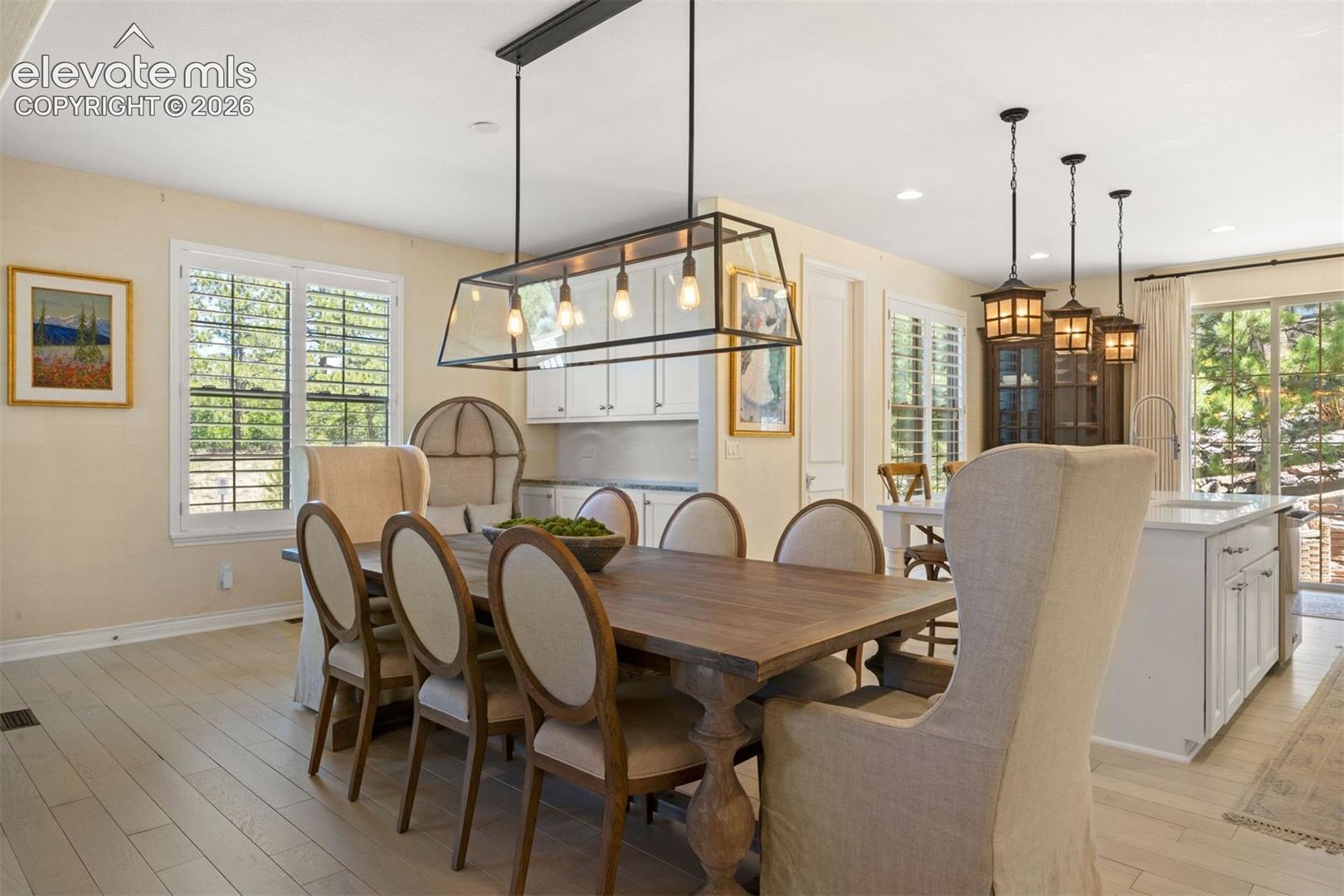 Dining area featuring light wood-finish flooring and a contemporary linear chandelier
