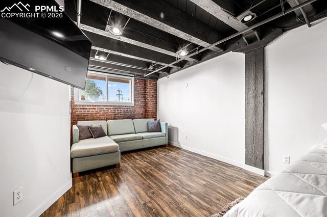Living room with brick wall and wood finished floors