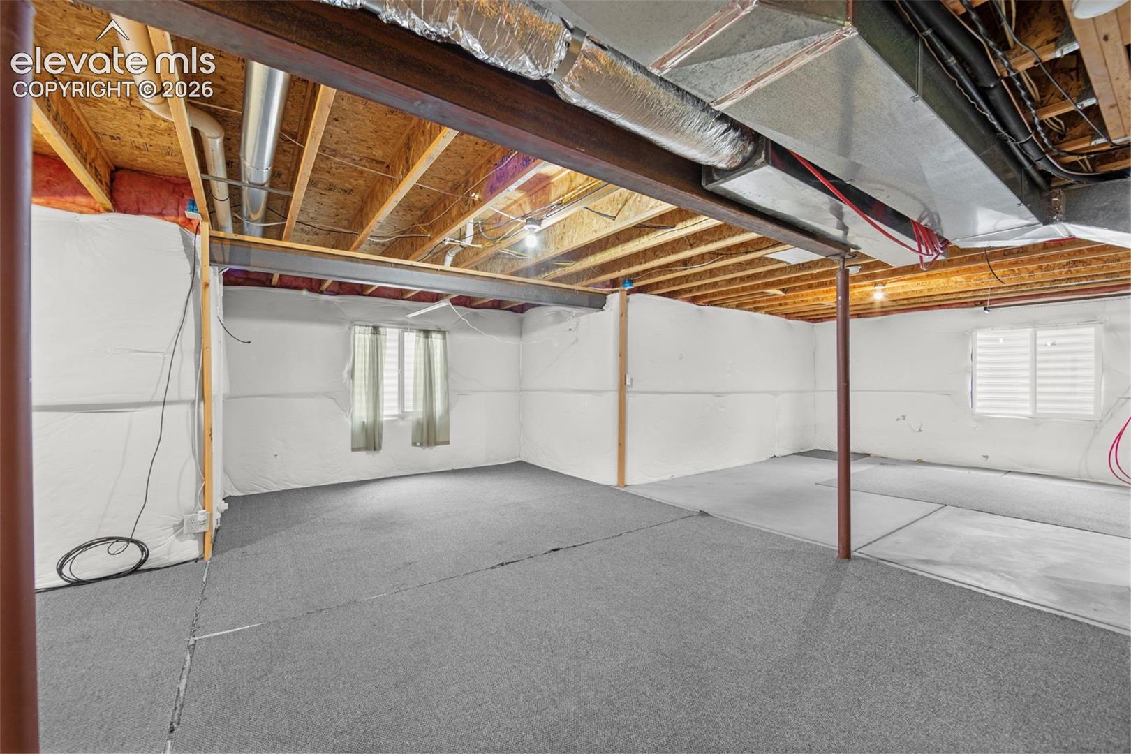 Expansive lower level with both carpeted and concrete flooring sections
