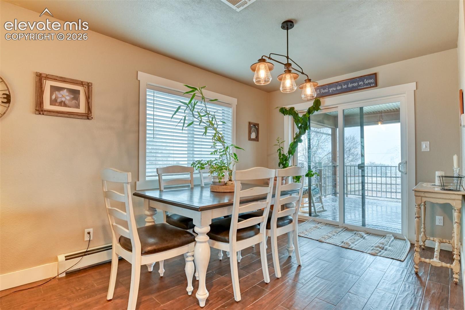 Dining area featuring wood finished floors and a baseboard radiator