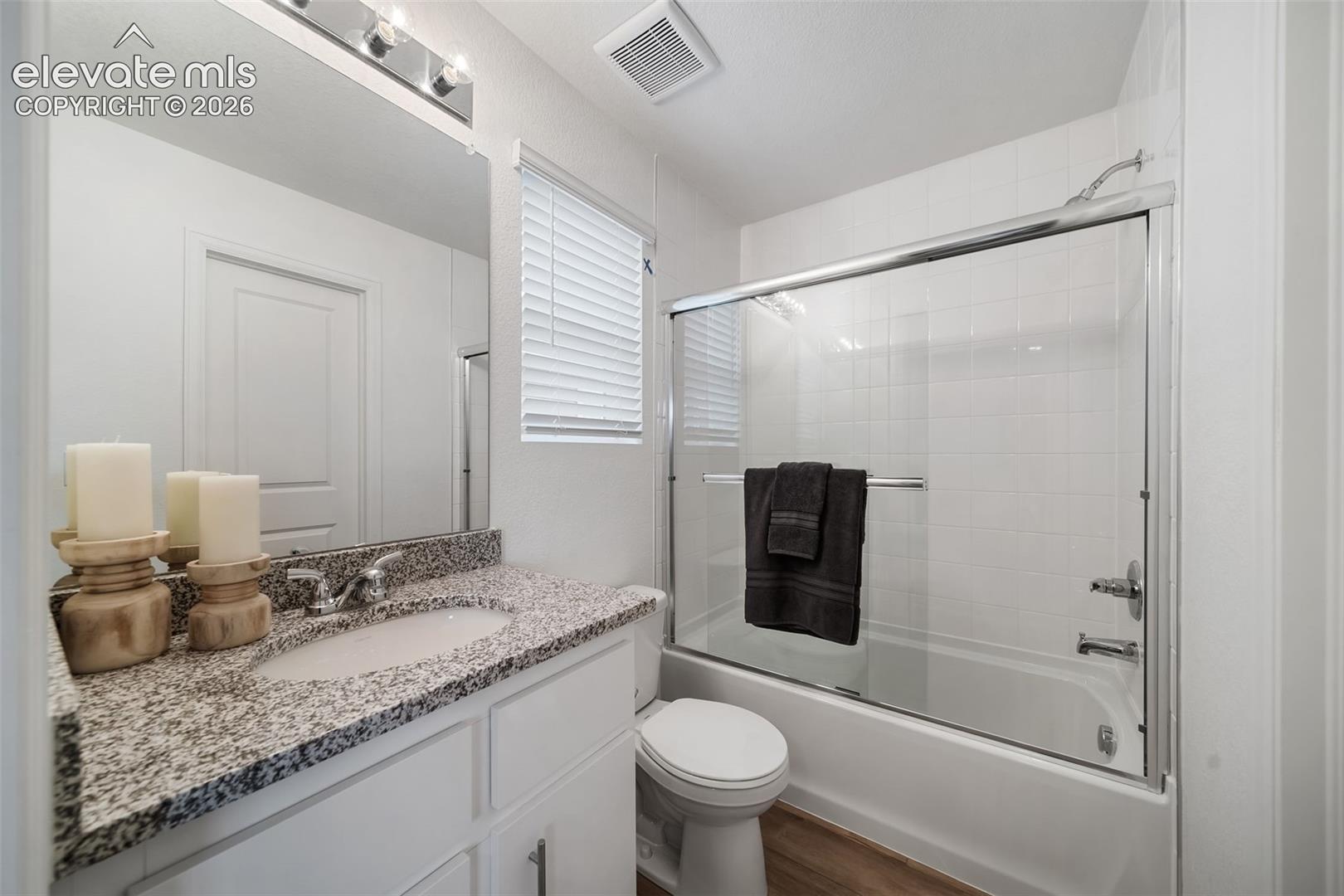 White vanity with a granite-style countertop and an undermount sink
*photos of a model home*
