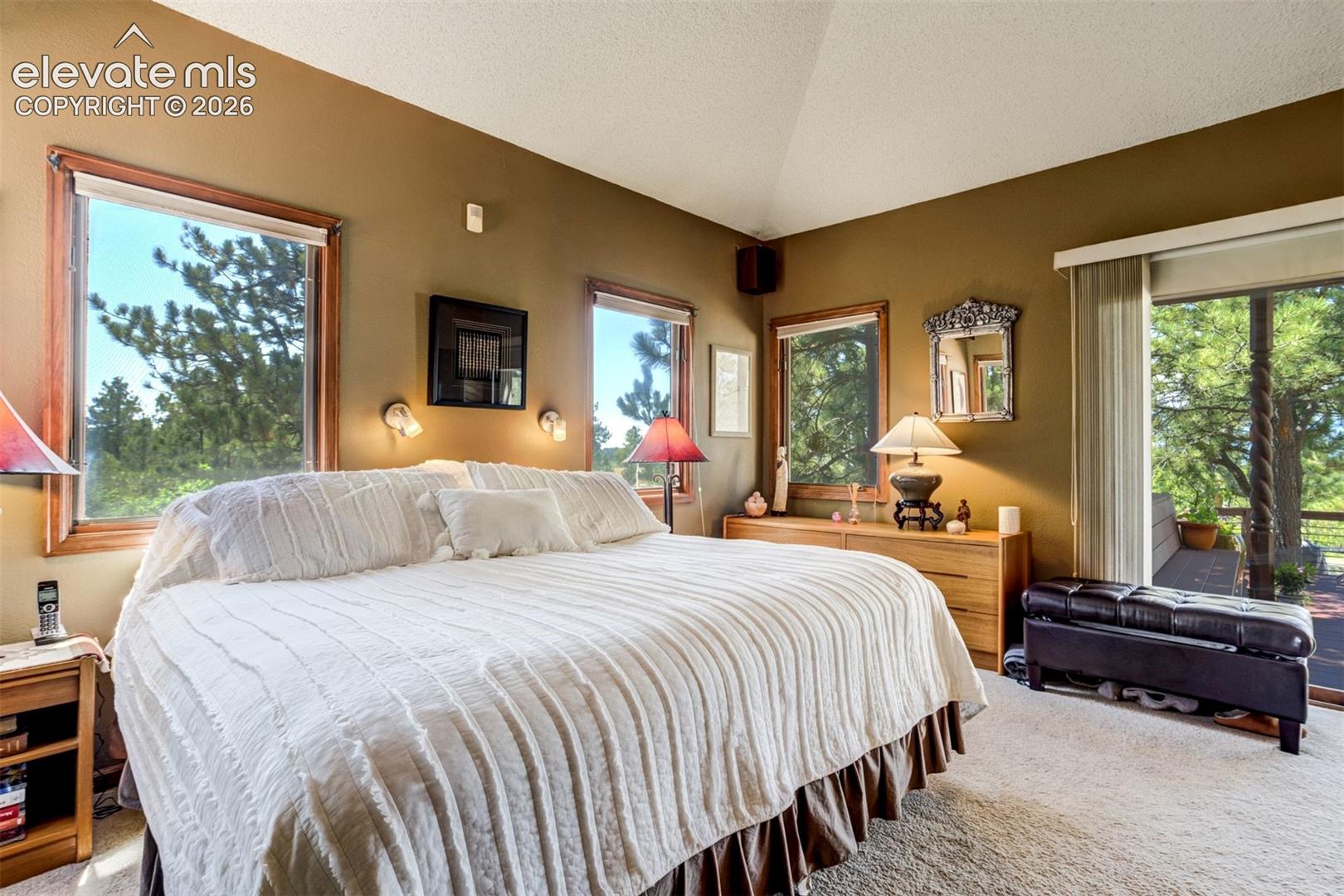 Primary bedroom has vaulted ceiling, sliding door that walks out to the large deck and views with attached bathroom