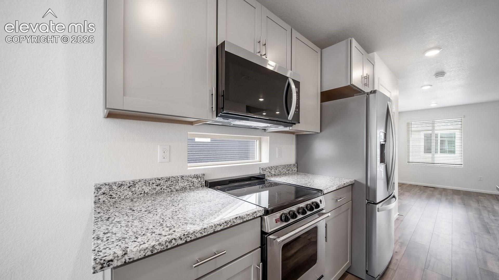 Kitchen featuring stainless steel appliances, light-toned cabinetry, and granite countertops
*photos of a model home*