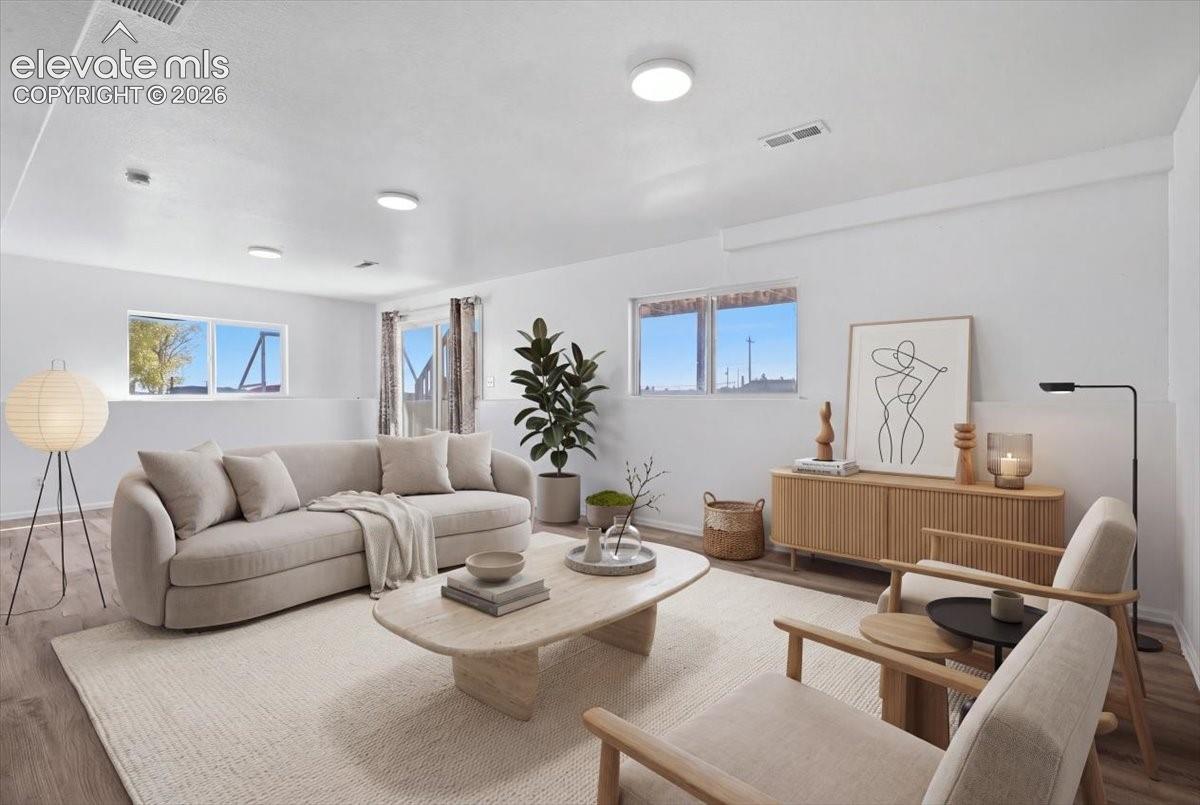 Neutral-toned interior space featuring wood-finish flooring, recessed lighting, and horizontal sliding windows