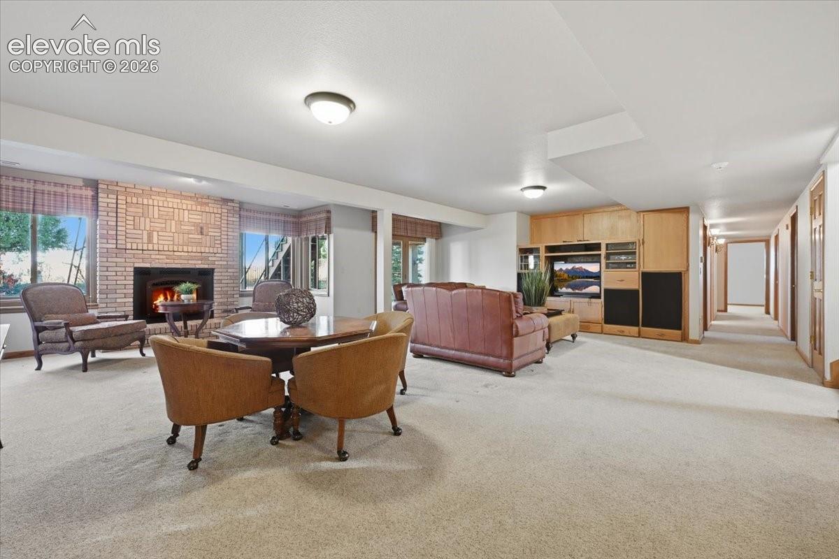 Gas fireplace with intricate brick surround offers another viewpoint to this open game/media room. 