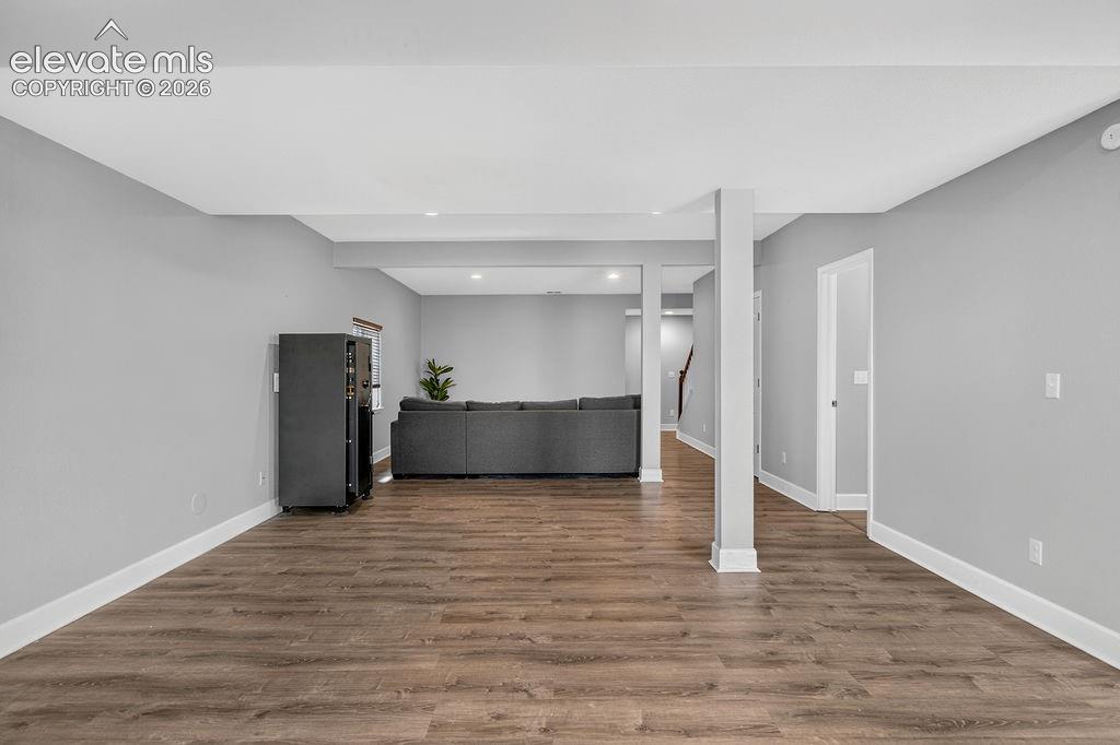 Wood-finish flooring with white trim, recessed lighting, and neutral wall tones