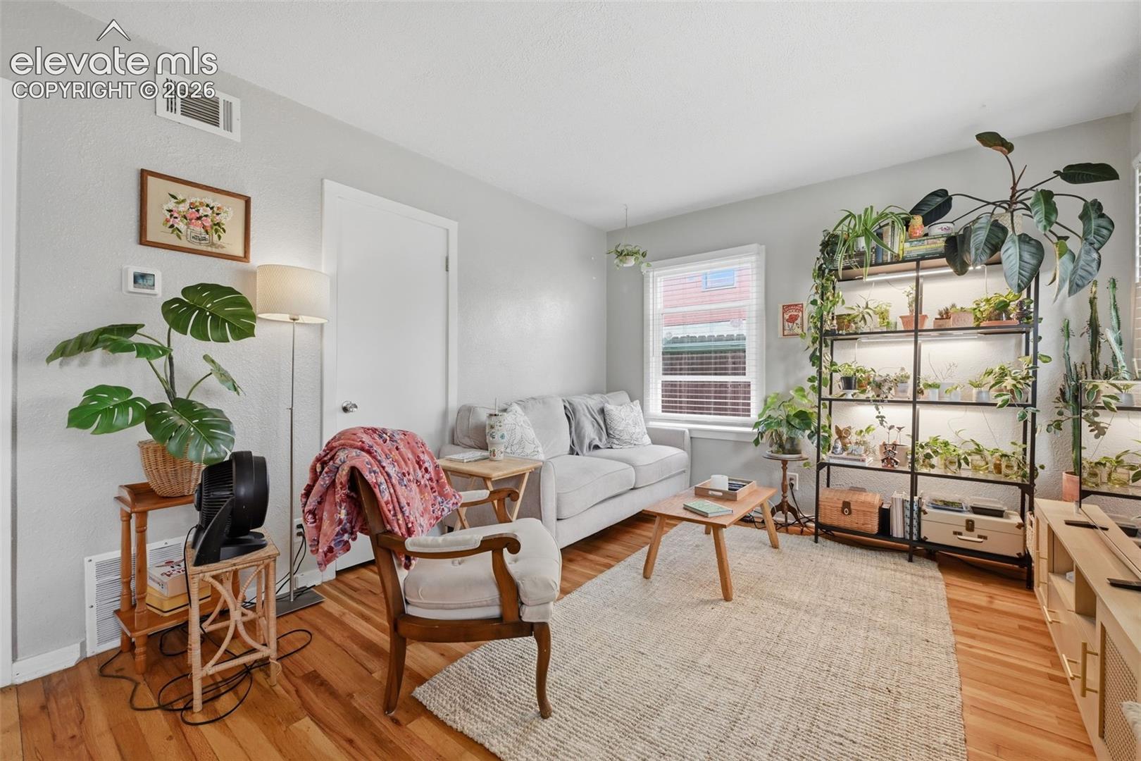 Wood-finish flooring, light grey wall paint, and a window with blinds