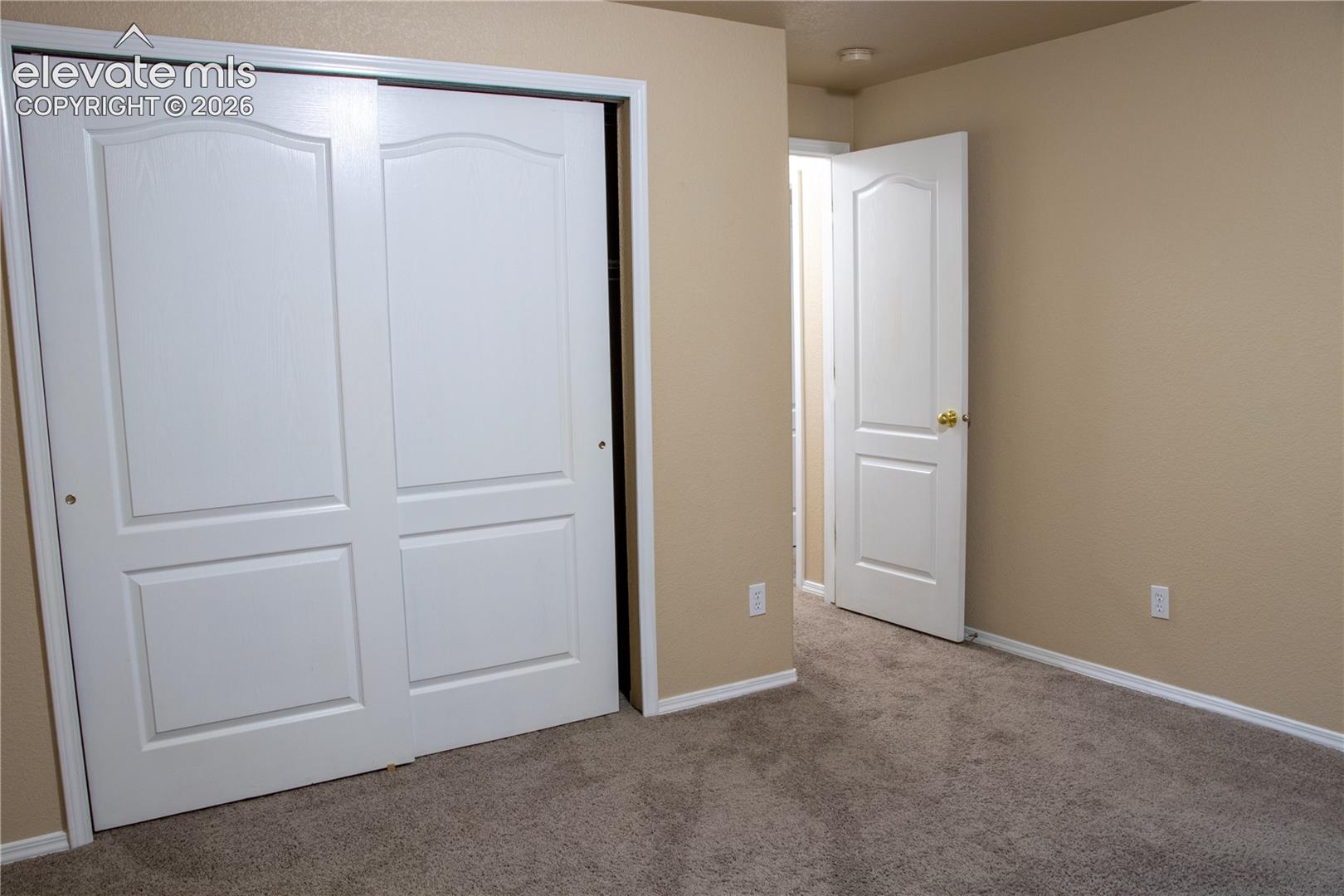 Bedroom featuring neutral-toned walls, carpet flooring, and white trim