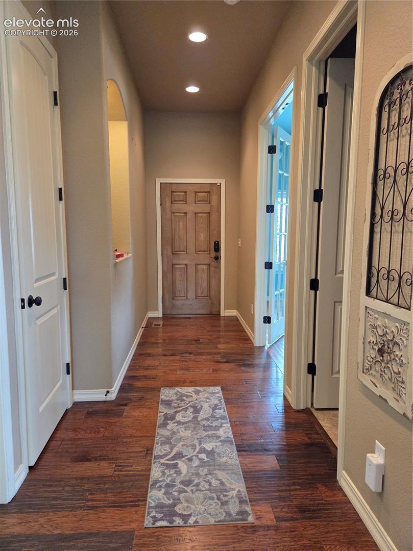 Entryway featuring wood-finish flooring, recessed lighting, and a paneled entry door