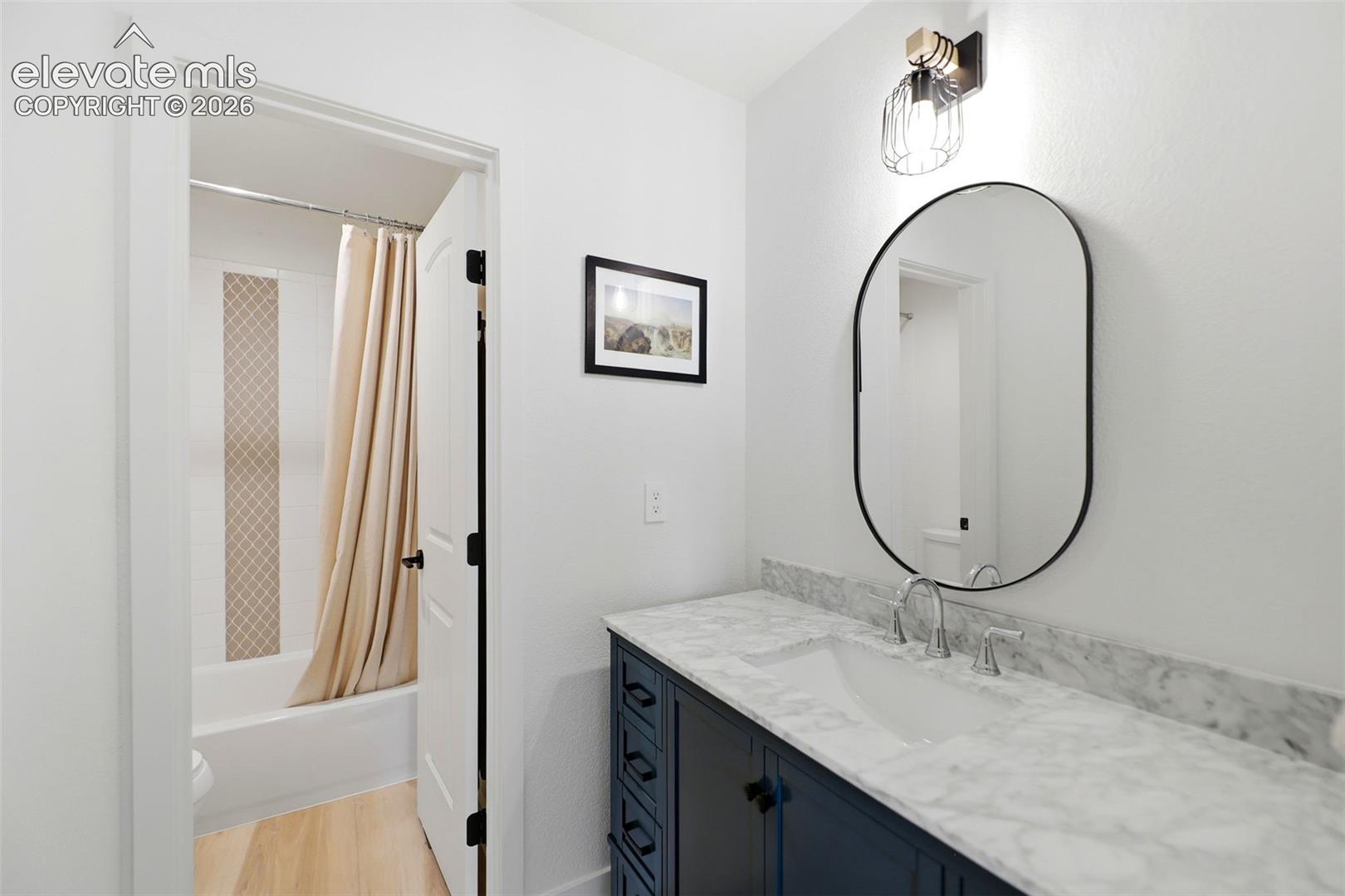Dark wood-finish vanity with a white basin and polished chrome faucet