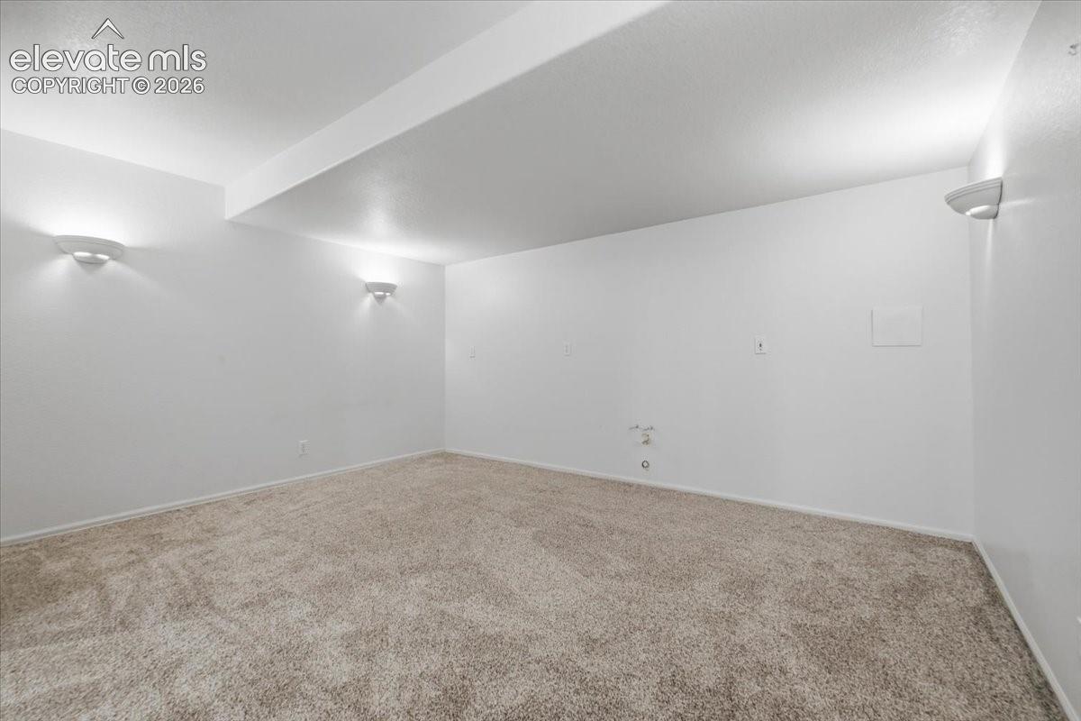 Neutral-toned carpet flooring and white walls with integrated wall sconces