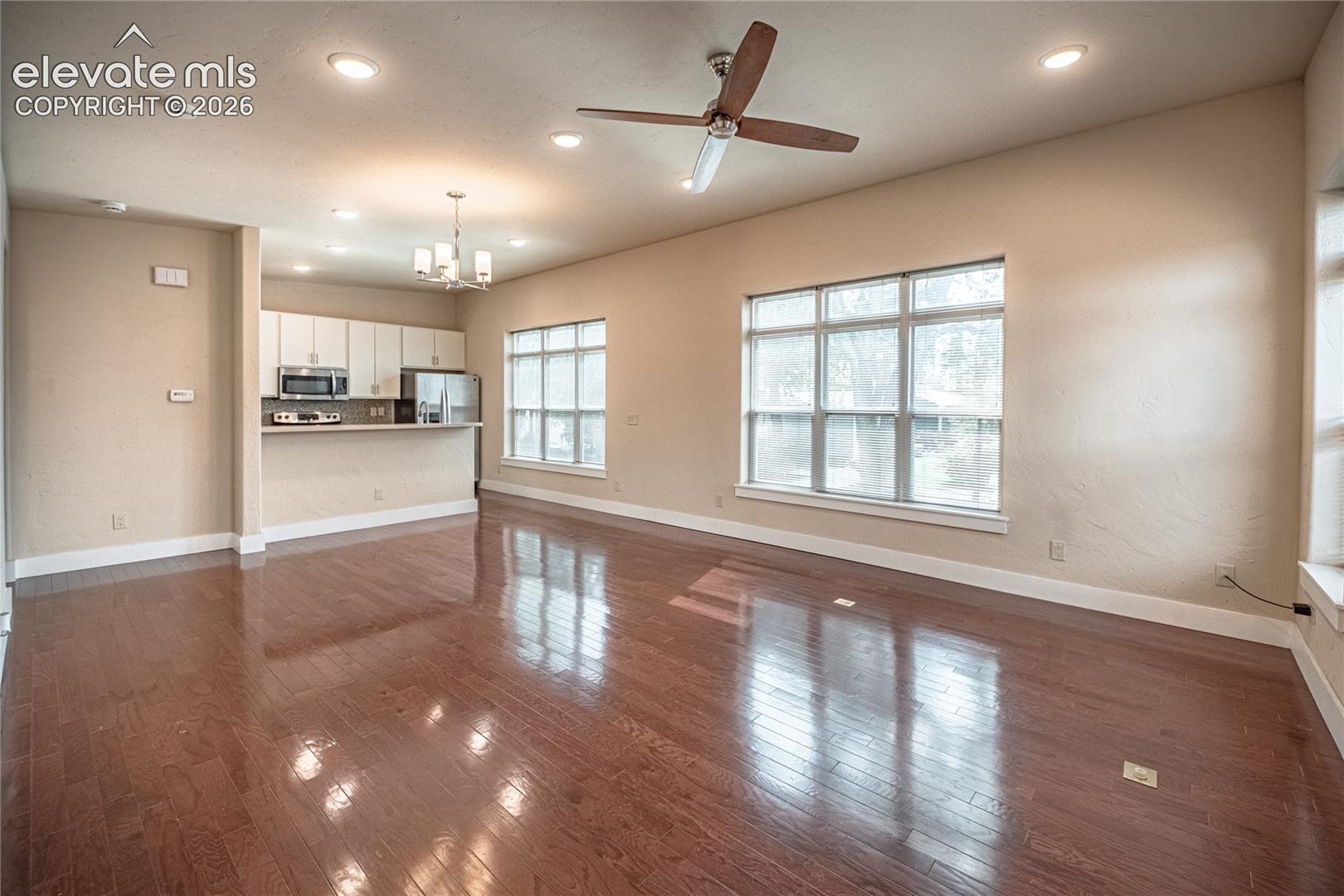 Open concept living area featuring wood-finish flooring, recessed lighting, and a ceiling fan