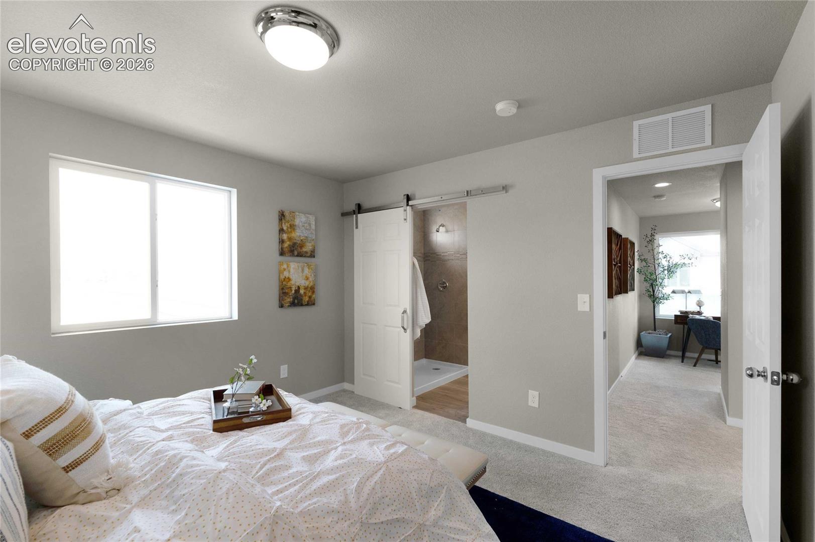 Recessed lighting, window with white trim, barn door entry to shower, light gray walls, and light-colored carpeting
*photos of a model home*