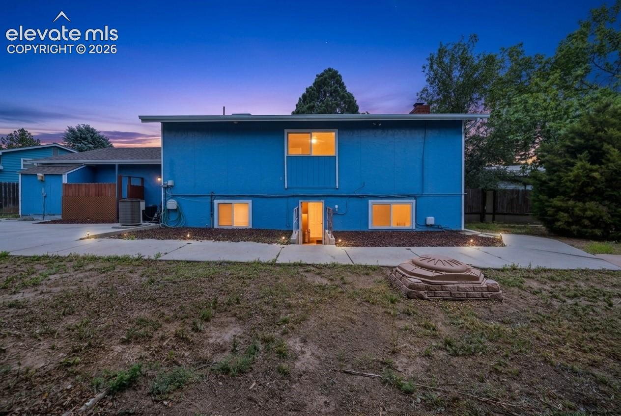 Exterior featuring a vibrant blue facade, multiple windows, and a paved patio area
