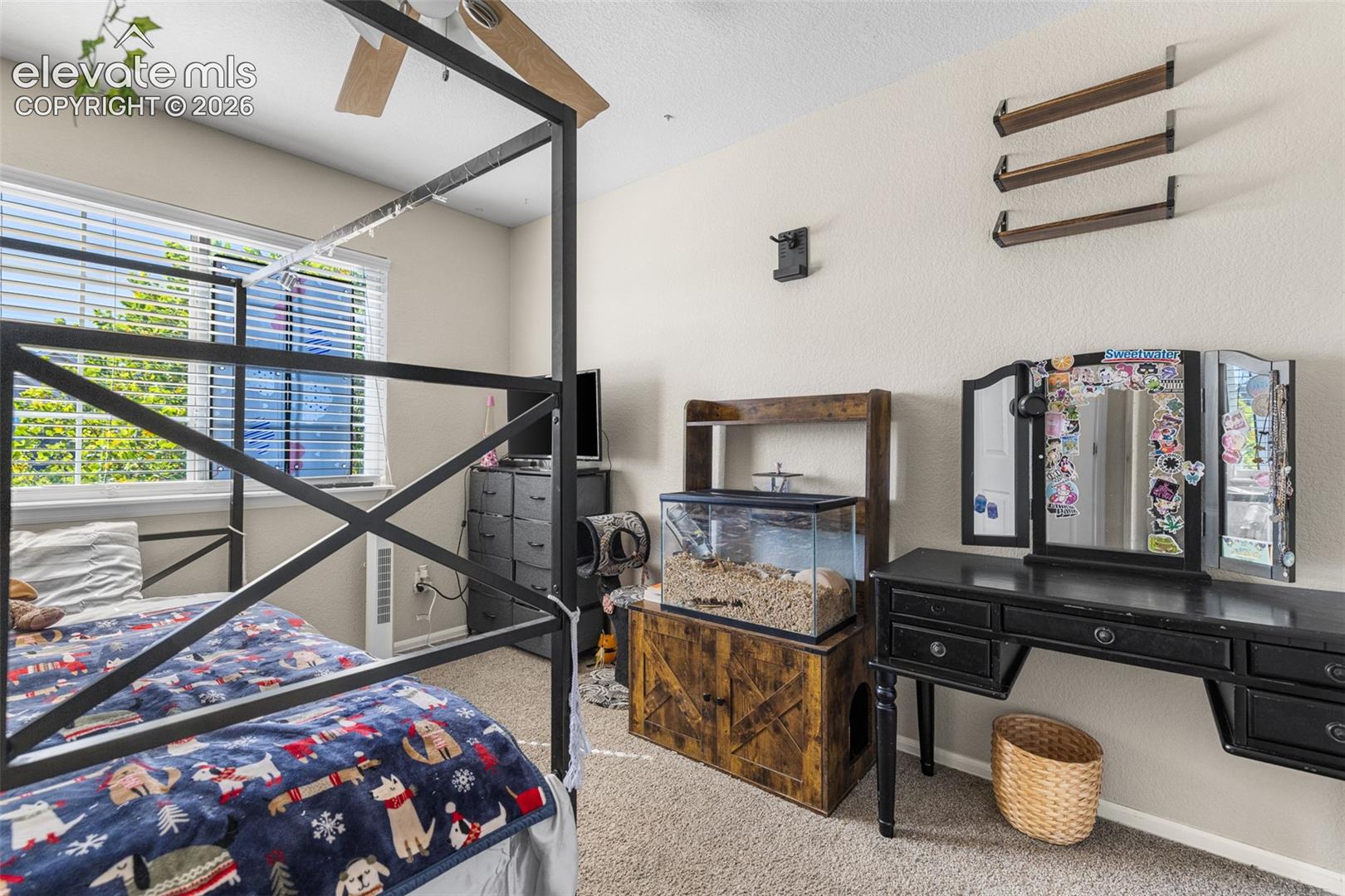 Bedroom featuring wall-to-wall carpeting, neutral interior paint, and an expansive window with horizontal blinds