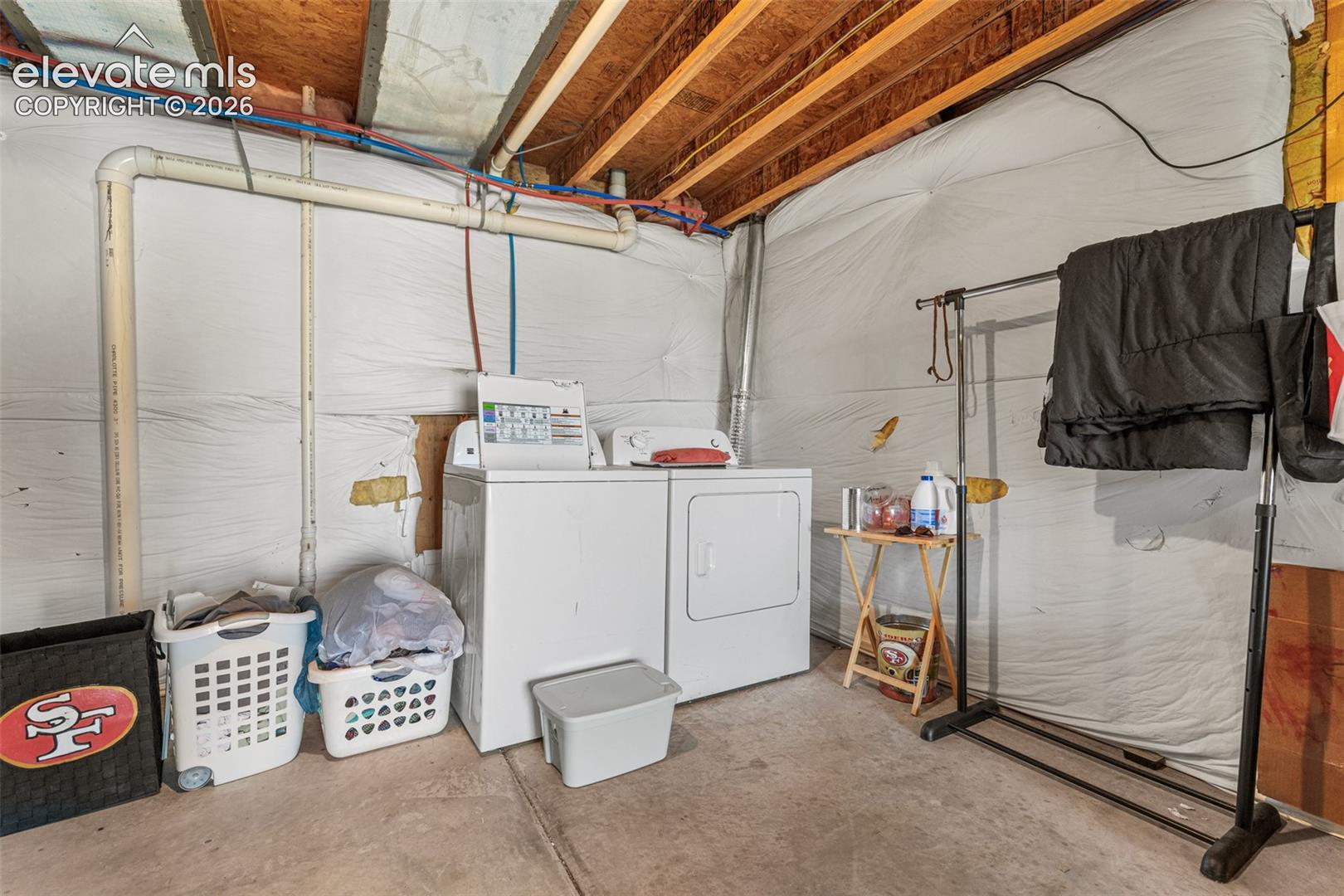 Unfinished utility area featuring exposed joists, concrete flooring, and insulated wall wrap