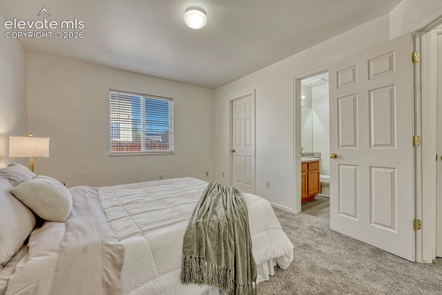 Primary Bedroom with walk in closet and view into the adjoining Primary Bathroom.
