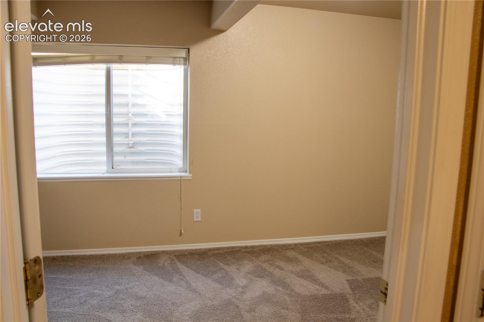 Neutral-toned walls complement the gray carpeting