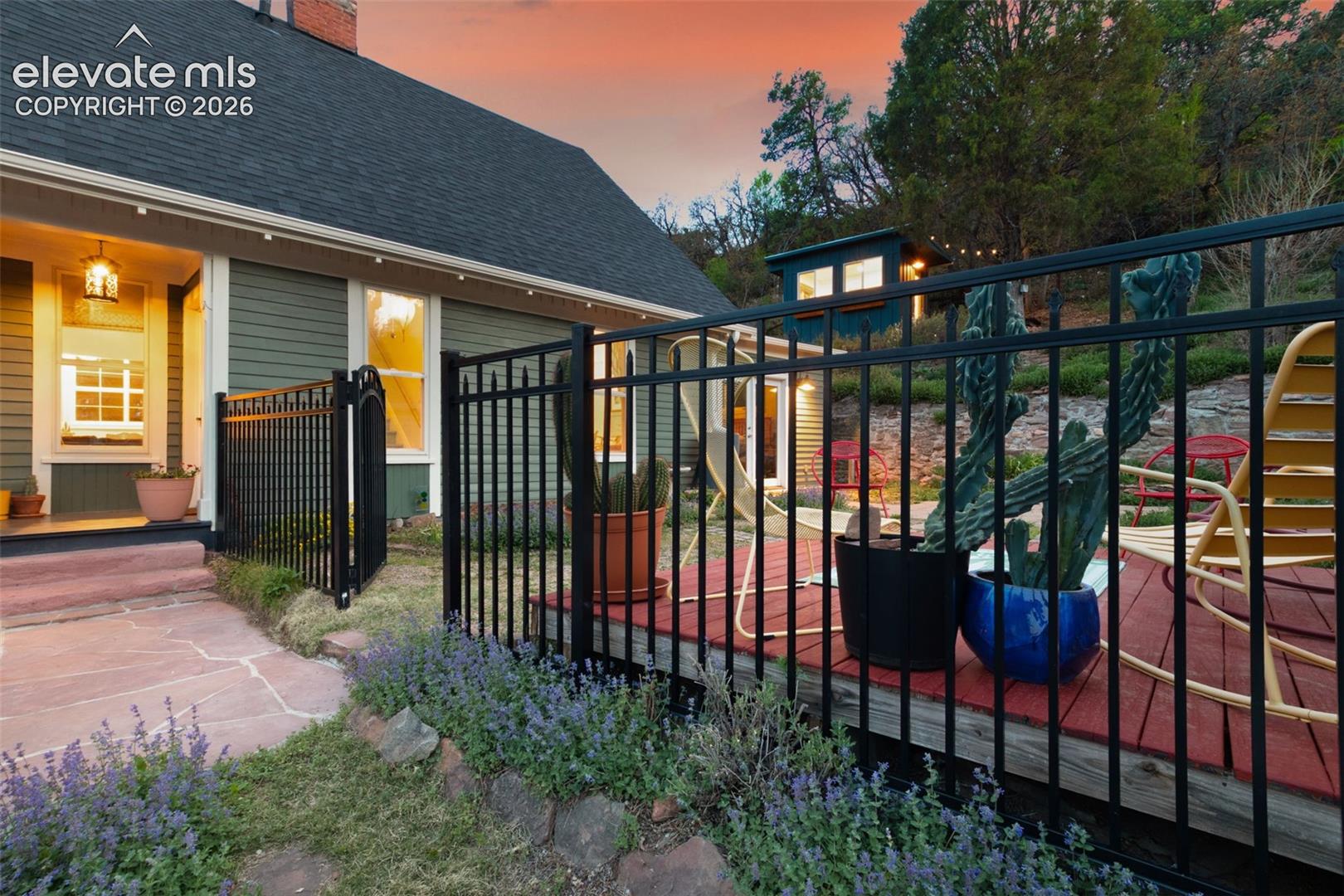 Exterior view featuring a flagstone pathway, a wooden deck, and backyard studio