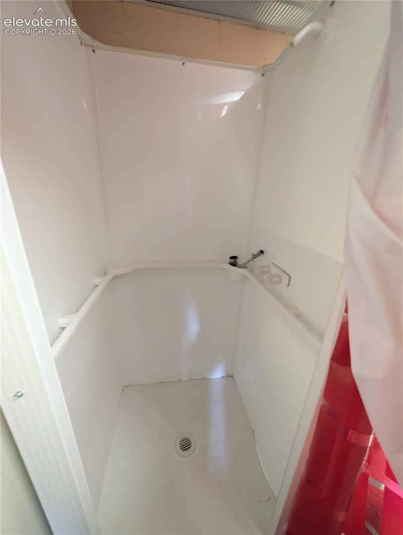 White shower stall with a floor drain