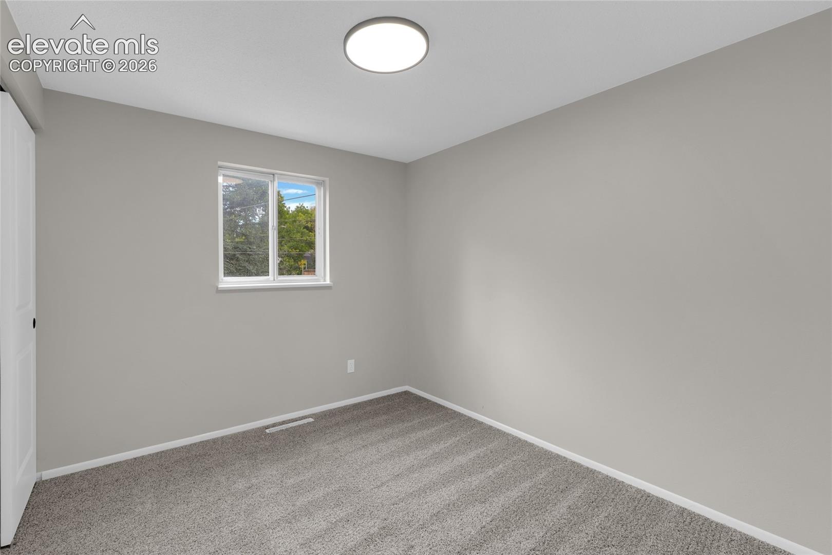 Neutral paint palette, flush mount ceiling light, and carpeted flooring