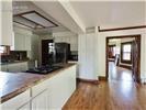 Kitchen featuring white cabinetry, wood-finish flooring, a kitchen island with a cooktop, and built-in recessed ceiling lighting