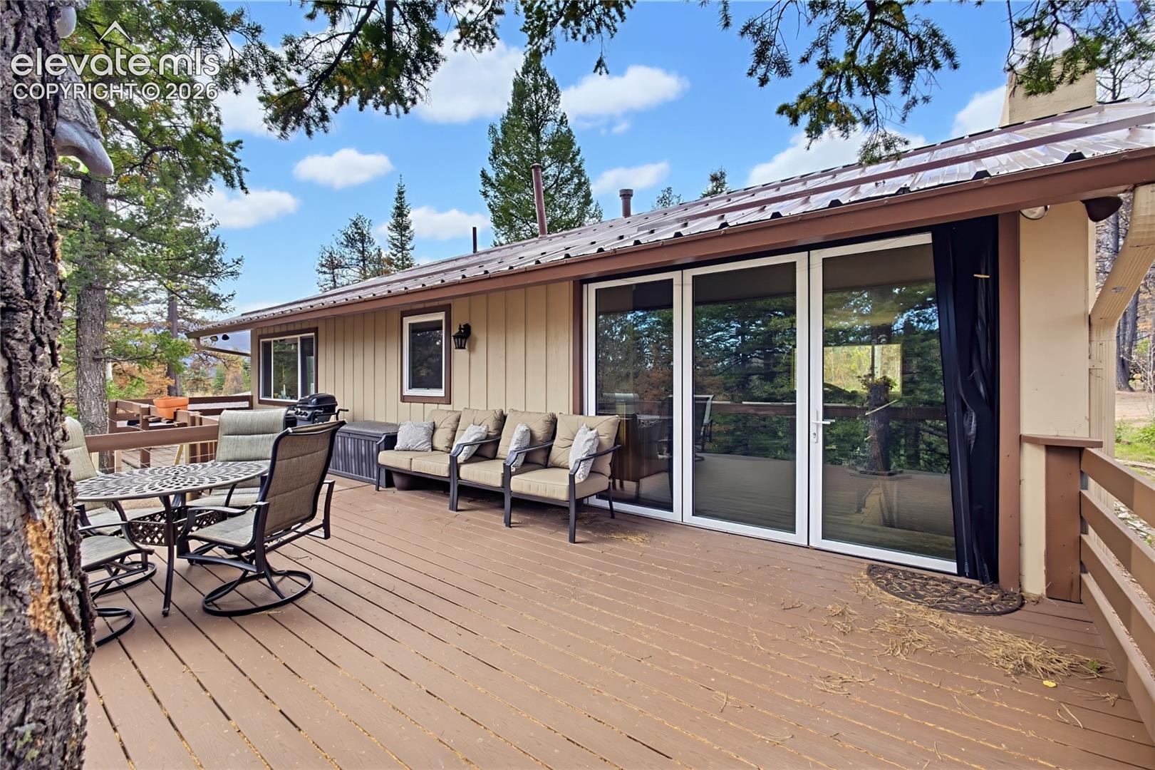 Expansive wooden deck featuring horizontal railings and a multi-panel glass door system
