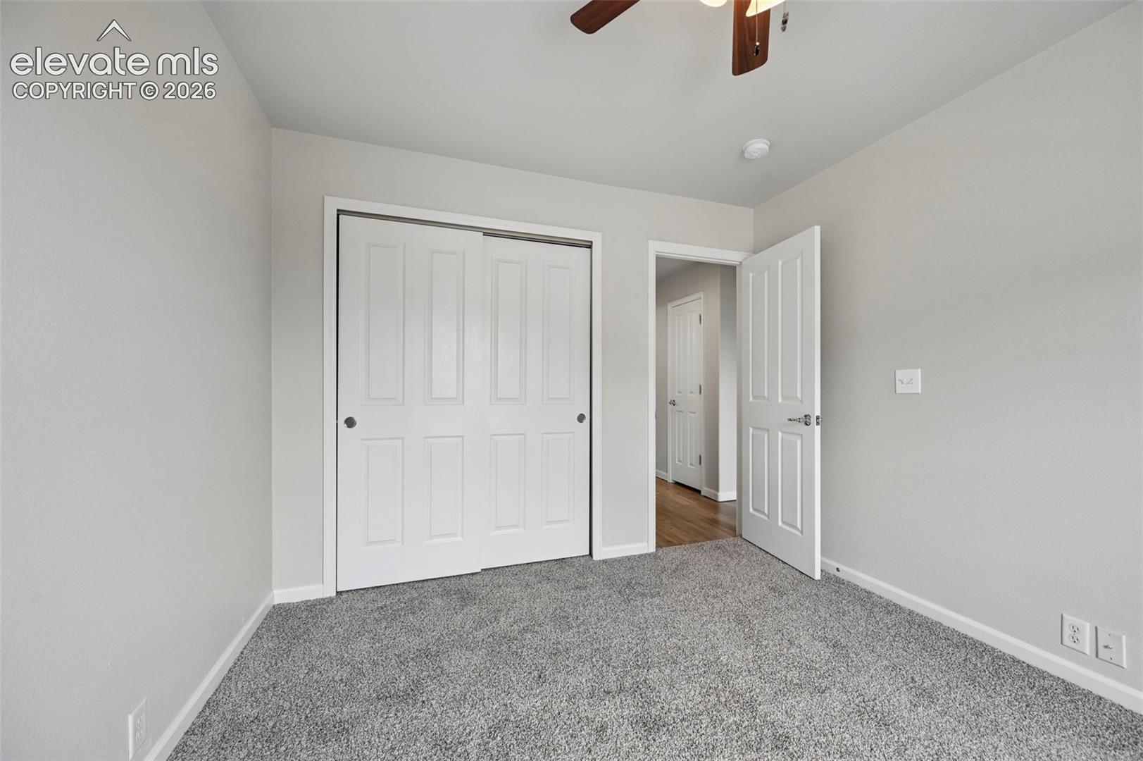 Room featuring gray carpet flooring, light gray wall paint, and white trim