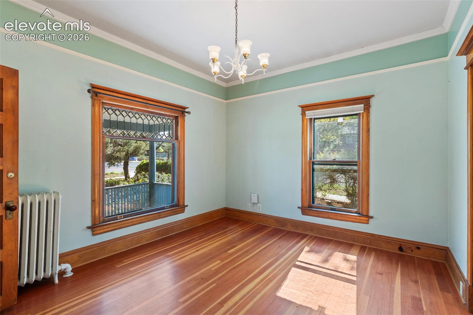 Main level living room featuring beautiful wood work and original window.