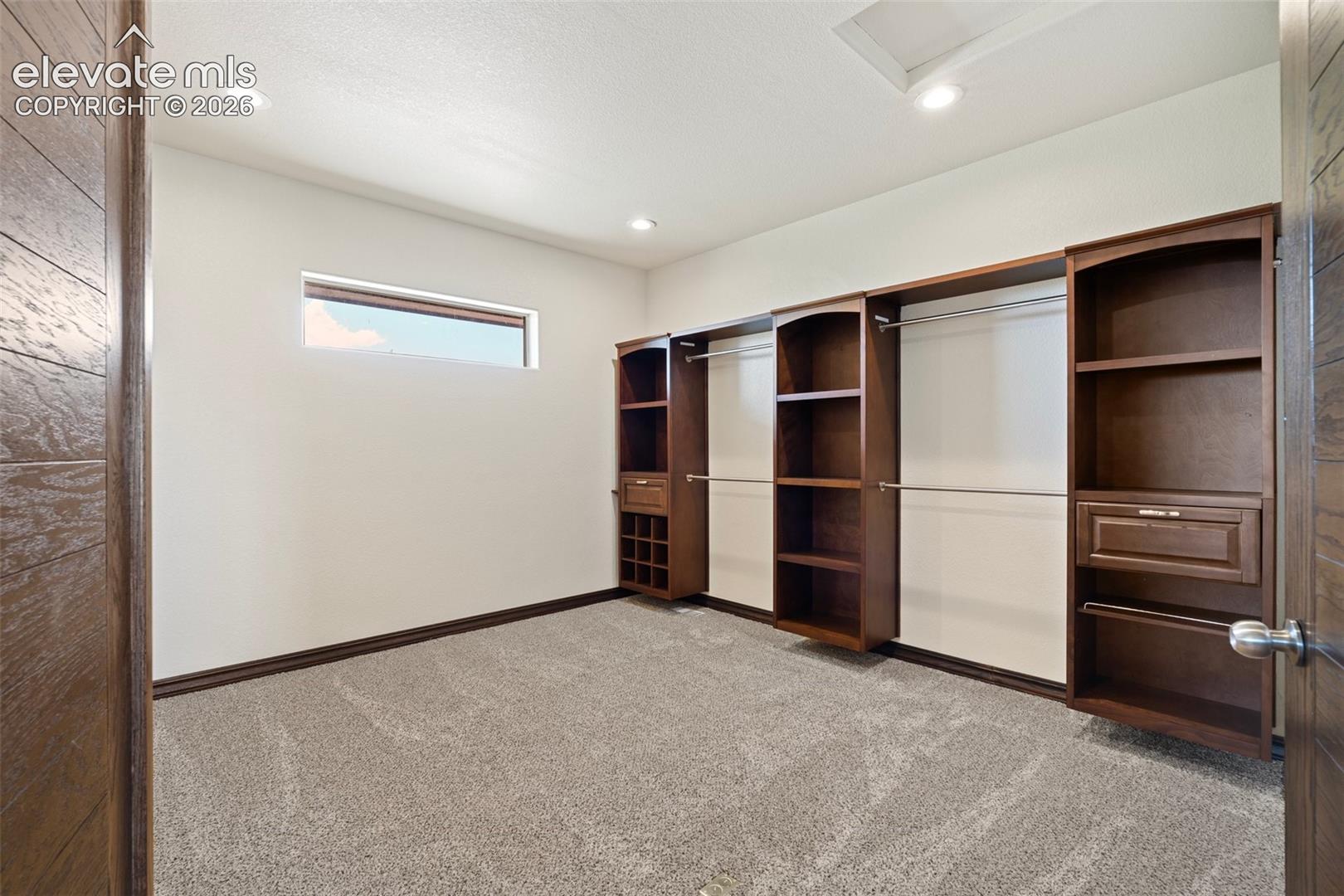 Built-in custom cabinetry system featuring shelving, drawers, and hanging rods