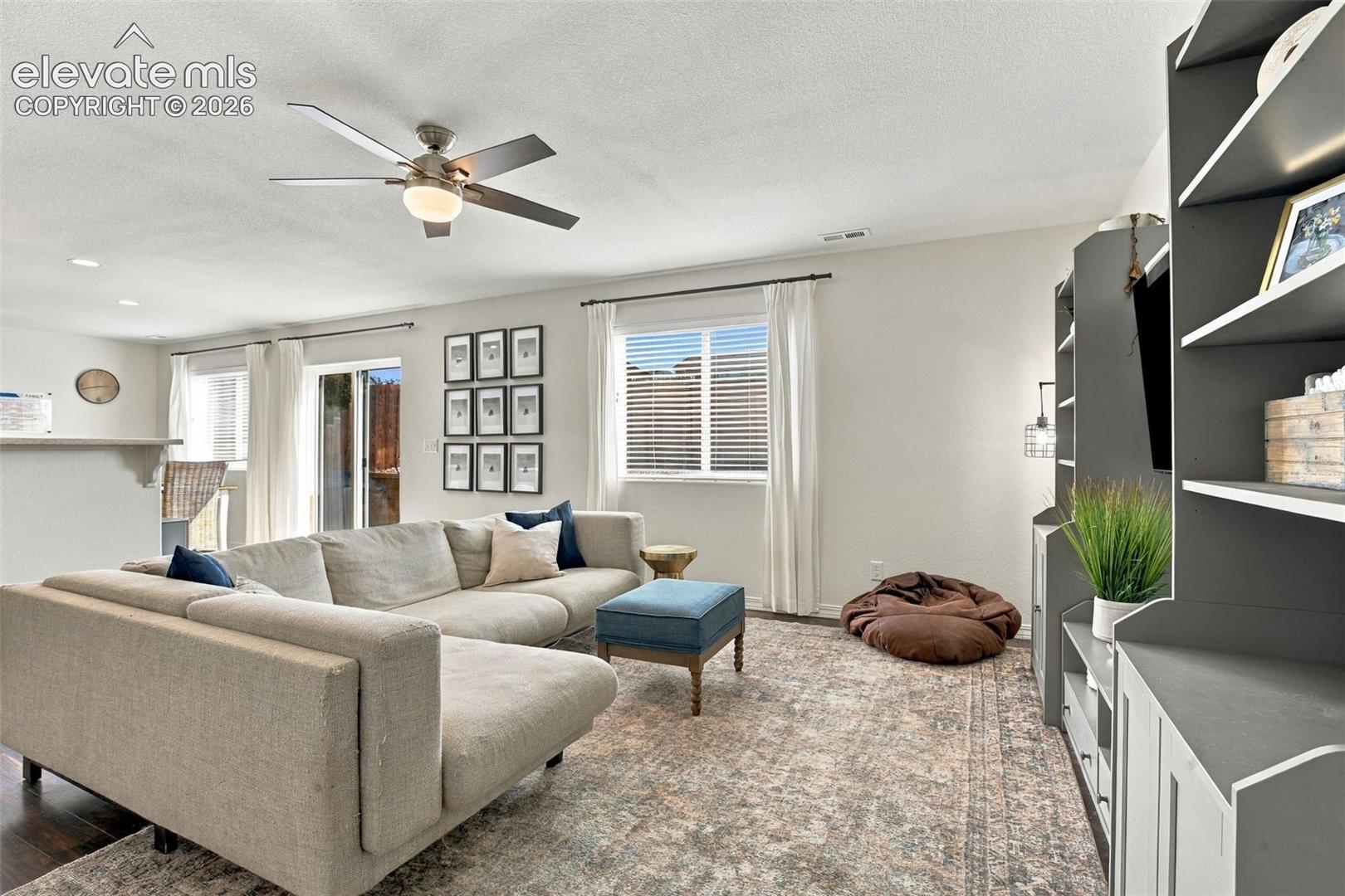Wood-finish flooring, recessed lighting, and a ceiling fan with integrated lighting