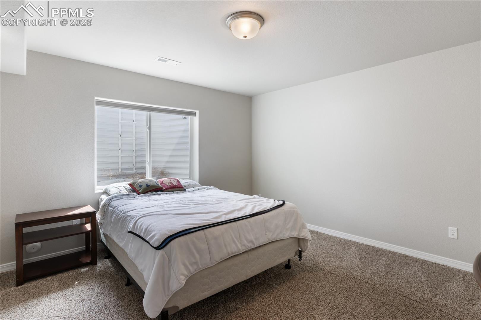 Comfortable secondary bedroom with neutral finishes and natural light