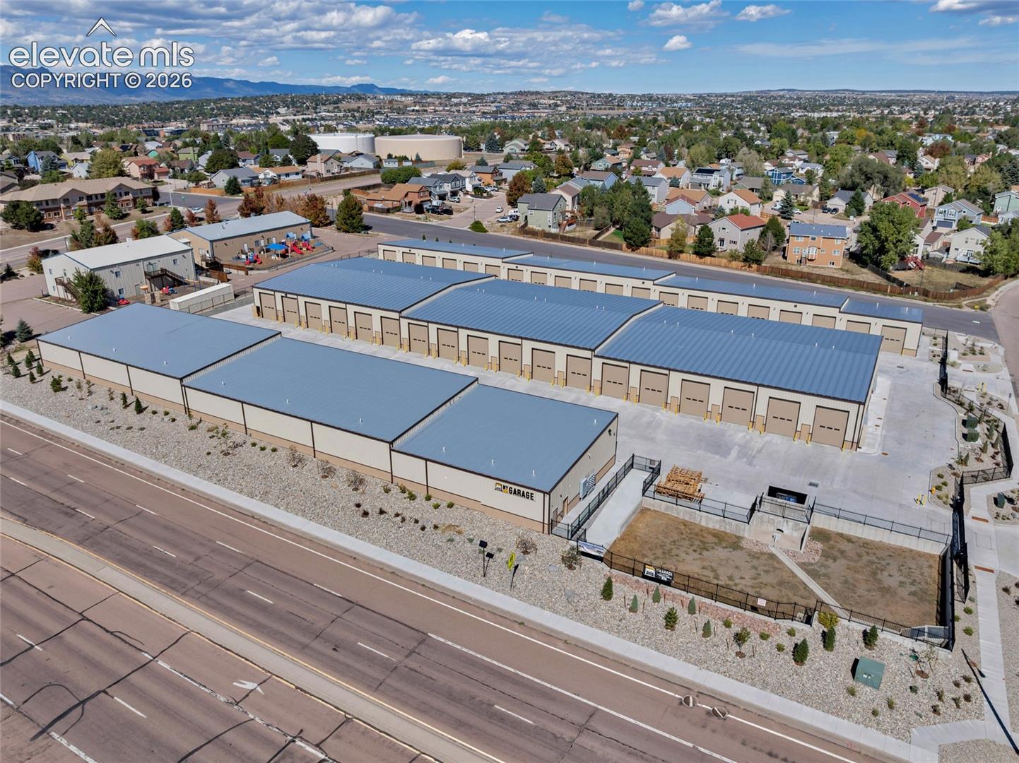 Multiple storage buildings with metal roofs and roll-up doors